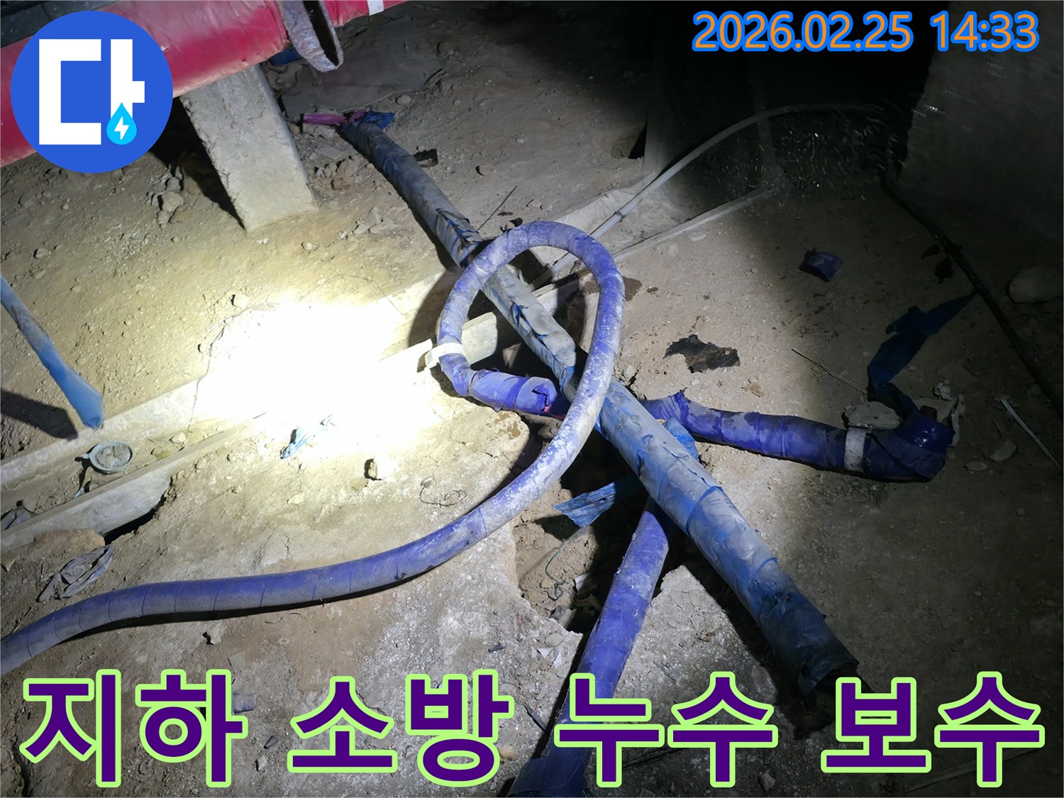 지하에 설치된 소방 배관에서 발생한 누수를-긴급하게 보수하고 있는-전문가의 작업 현장입니다
