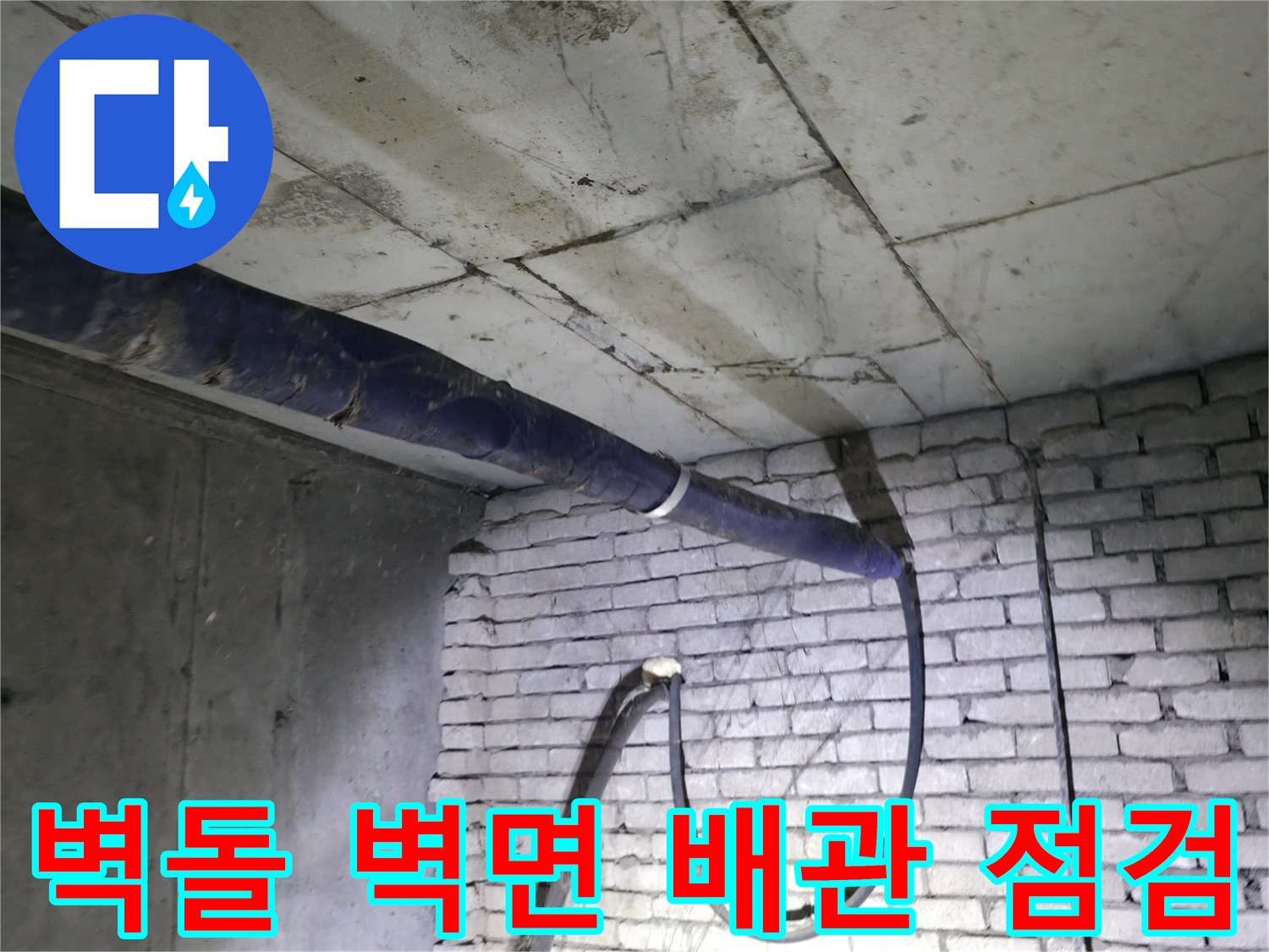 파란색 보온재로 감싸진 배관과 하얀 벽돌 벽면의 근접 촬영