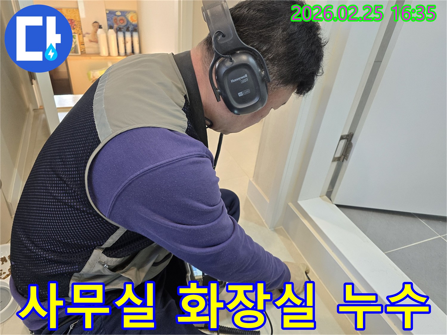 숙련된 누수 엔지니어가-청음식 탐지기를 이용해-사무실 화장실 바닥의-배관 누수 지점을-정밀하게 진단하고 있습니다