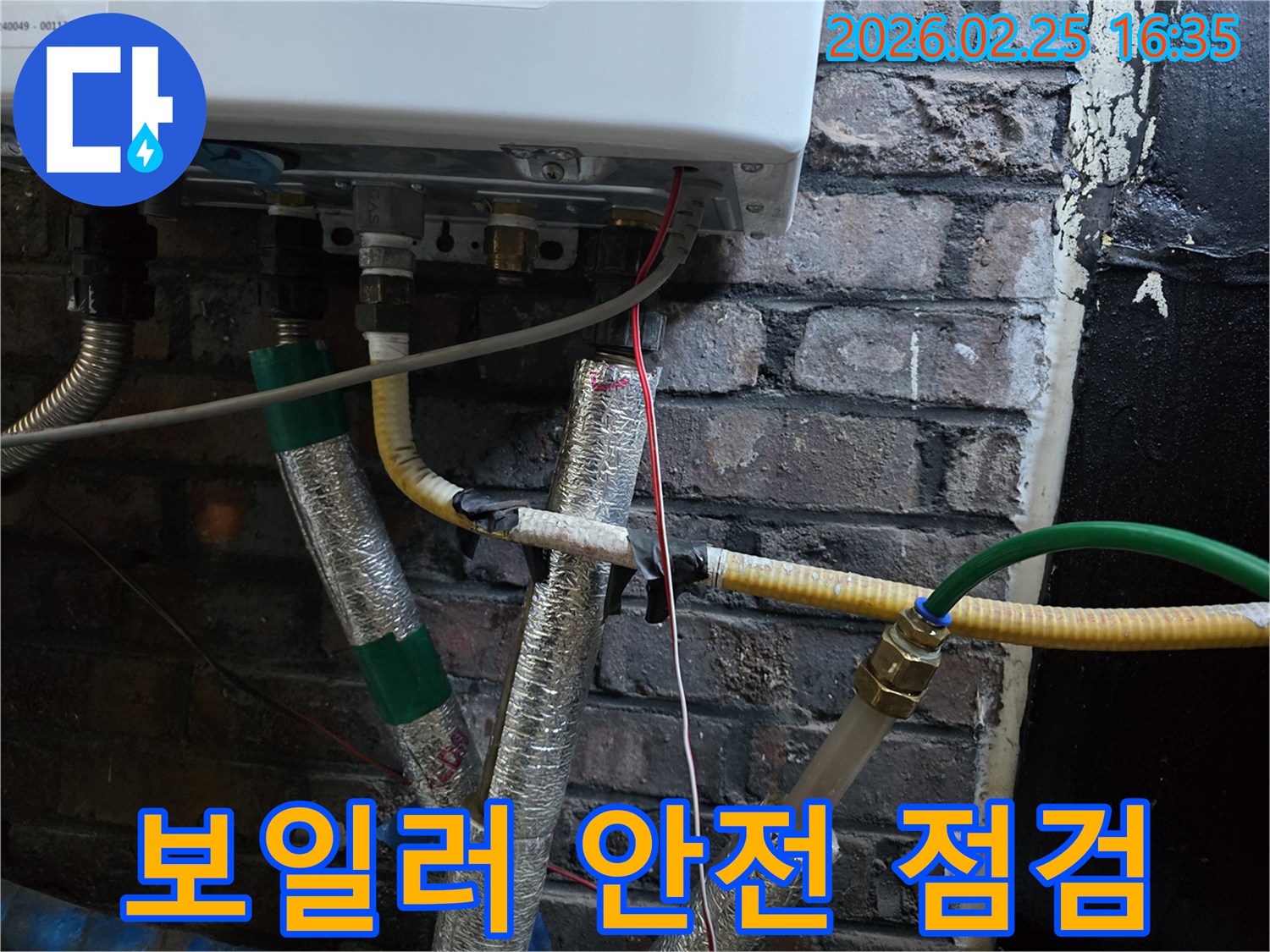 이 사진은-보일러 하단부의-배관과-전선들이-안전하게-설치된-모습을-보여주며-보일러 시스템의-전반적인-안전 상태를-나타냅니다.