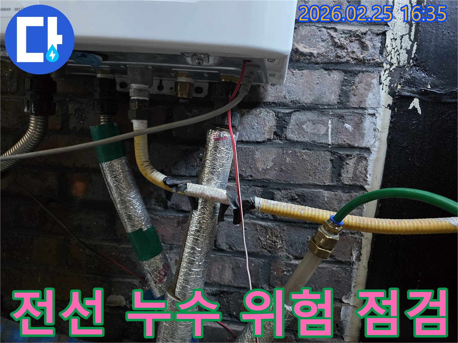 이 사진은-보일러 하단부의-배관들 사이로-지나가는-전선들을-보여주며-누수로 인한-전기적 위험성을-시사합니다.