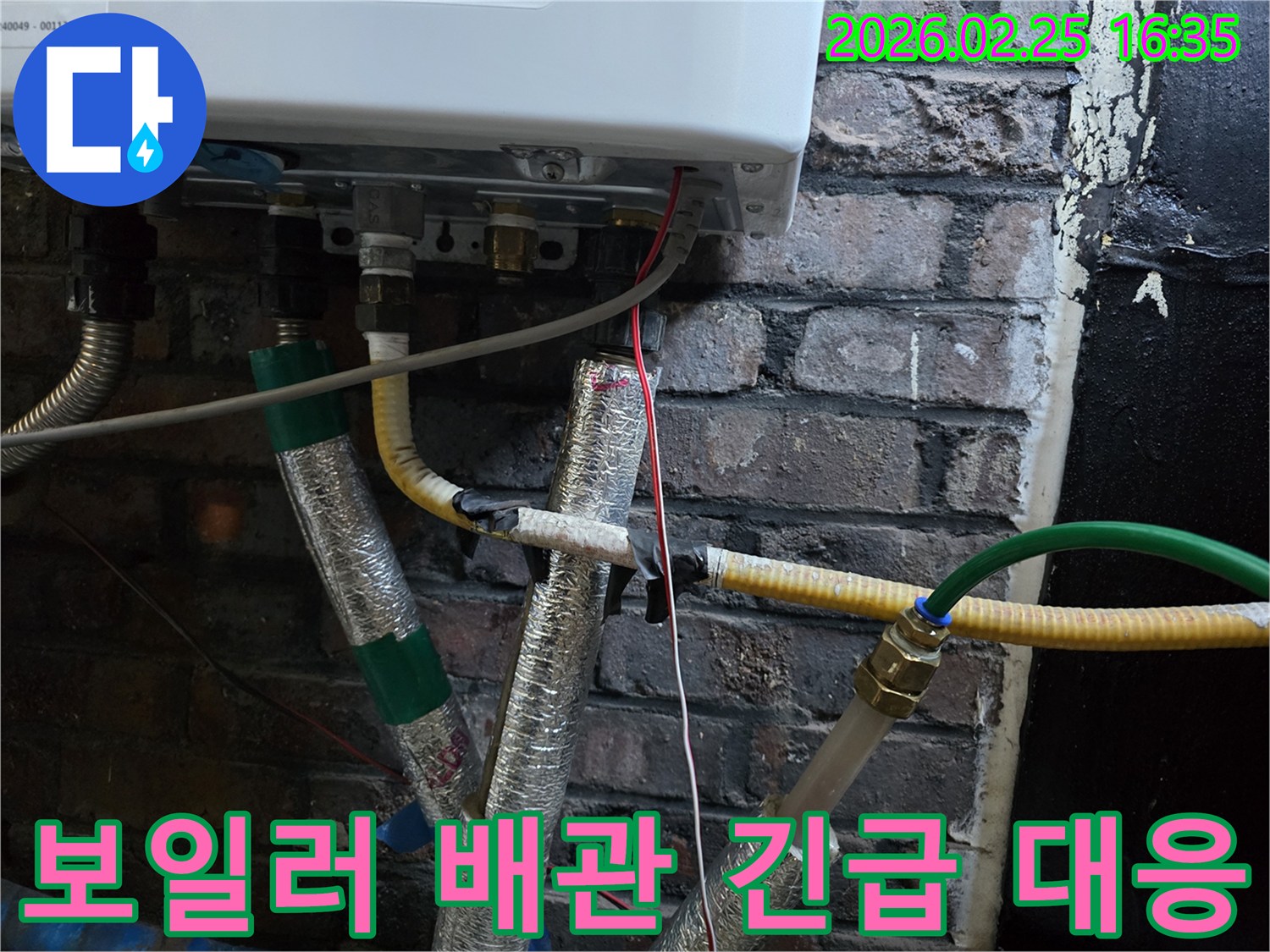 이 이미지는-벽에 설치된-보일러 하단부의-복잡한 배관 연결부와-전선-그리고-은색 단열재로-감싸진-파이프들을-보여주며-긴급한 누수 상황에-대한-신속한 대응이-필요함을-암시합니다.