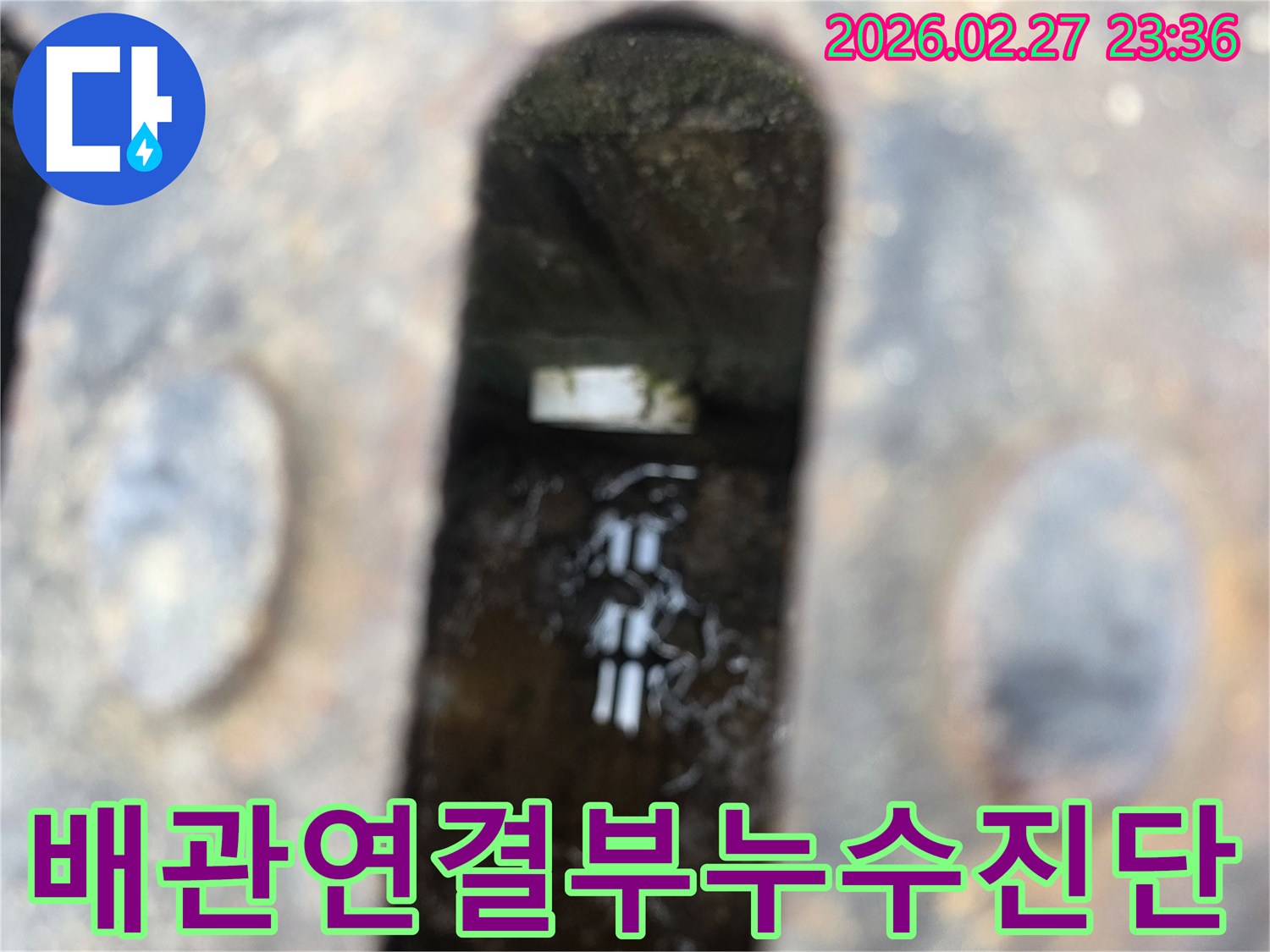 녹슨-철제-배수구-아래-고인-물과-물속에-잠긴-배관-연결부가-보이는-배관-누수-현장