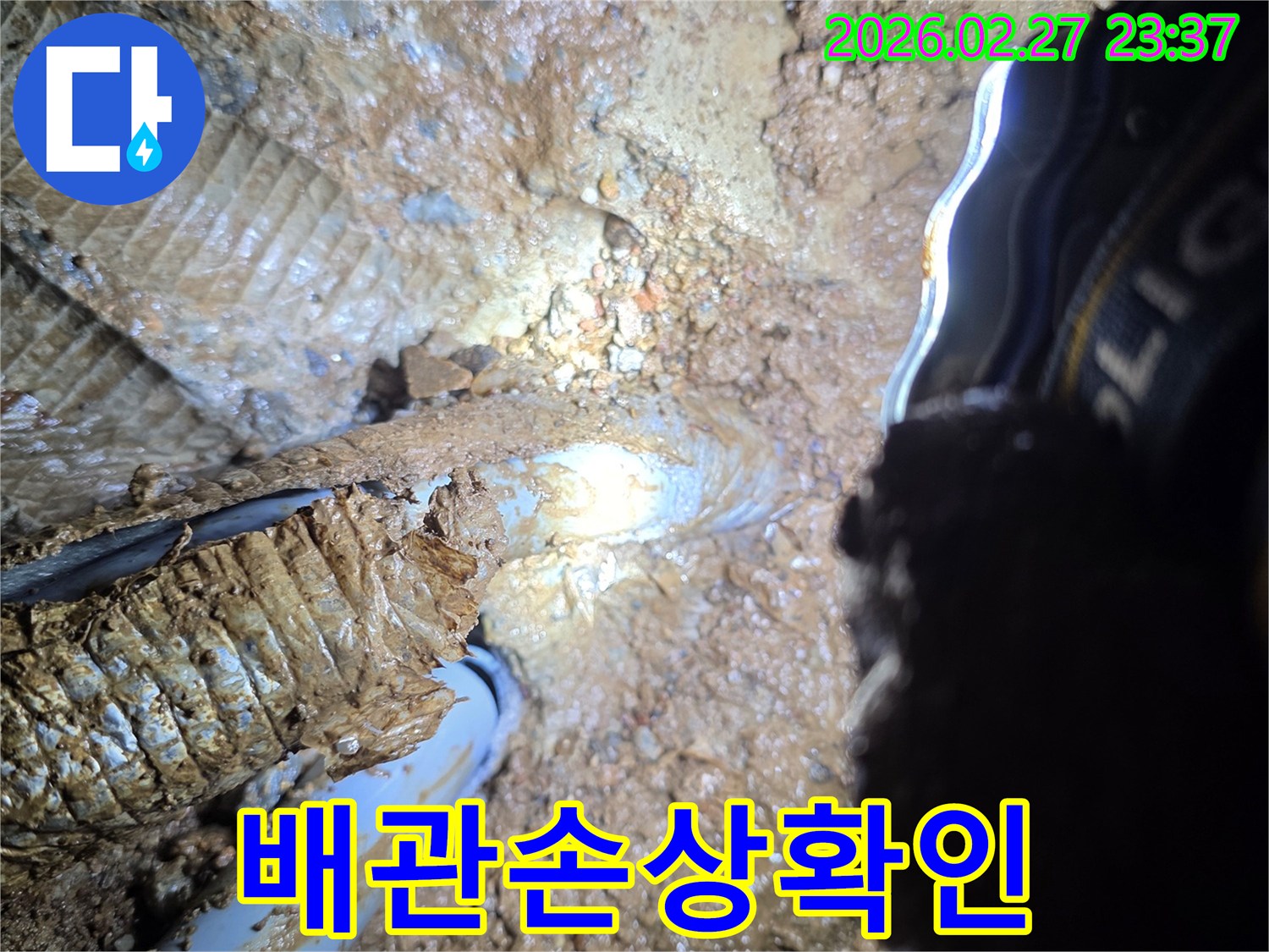 흙과-진흙으로-뒤덮인-상태에서-누수가-진행-중인-배관의-손상-부위를-근접-촬영한-이미지입니다