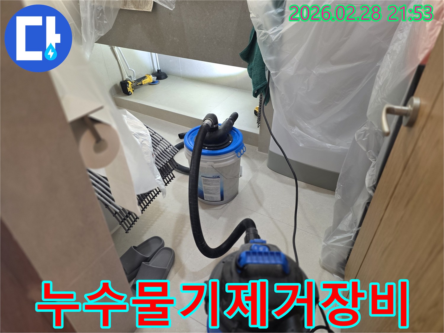 이 이미지는 누수 현장에서-습식 청소기와 연결된 흡입 장치를 사용하여-고여있는 물기를 제거하고-탐지 작업을 위한 깨끗한 환경을 만드는 과정을 보여줍니다.