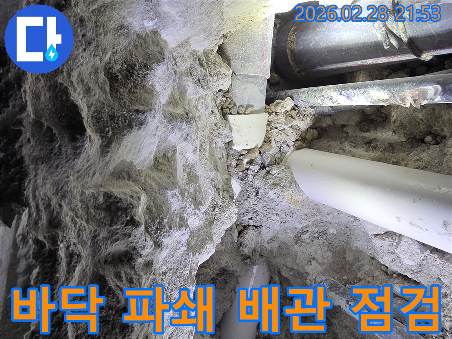 콘크리트 바닥을 파쇄하여-지하에 매설된-다양한 배관들을-드러내고-점검하는 작업 현장