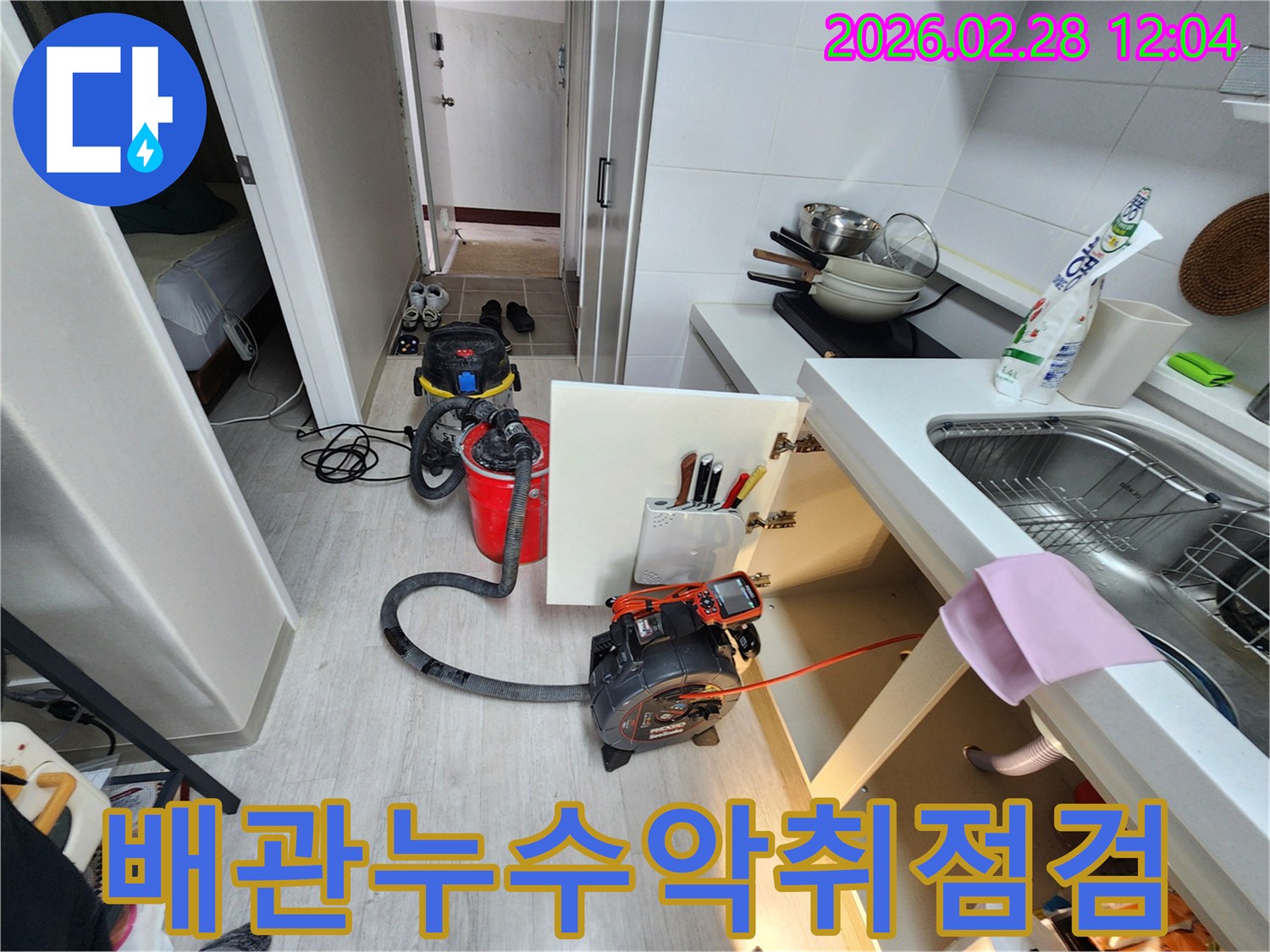 싱크대-아래-배관에서-발생하는-누수와-악취-문제를-진단하기-위해-내시경-장비와-흡입기를-설치한-모습