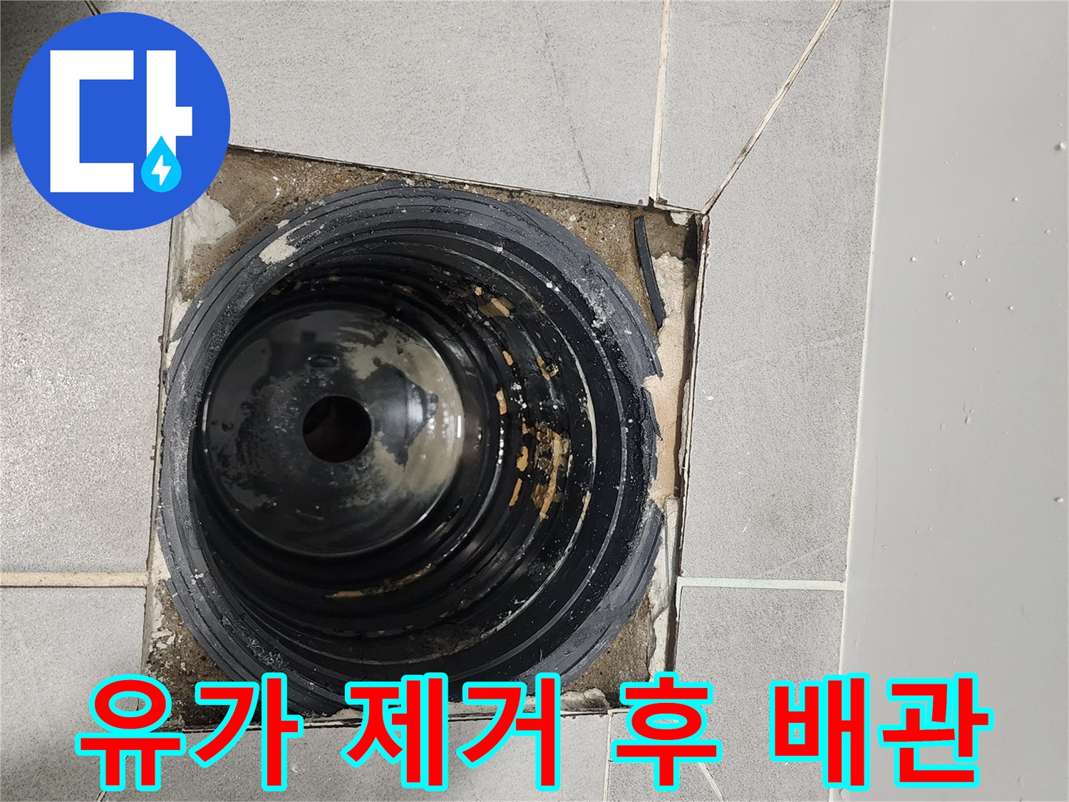 욕실 바닥 배수구 주변의 노출된 배관과 균열 부위
