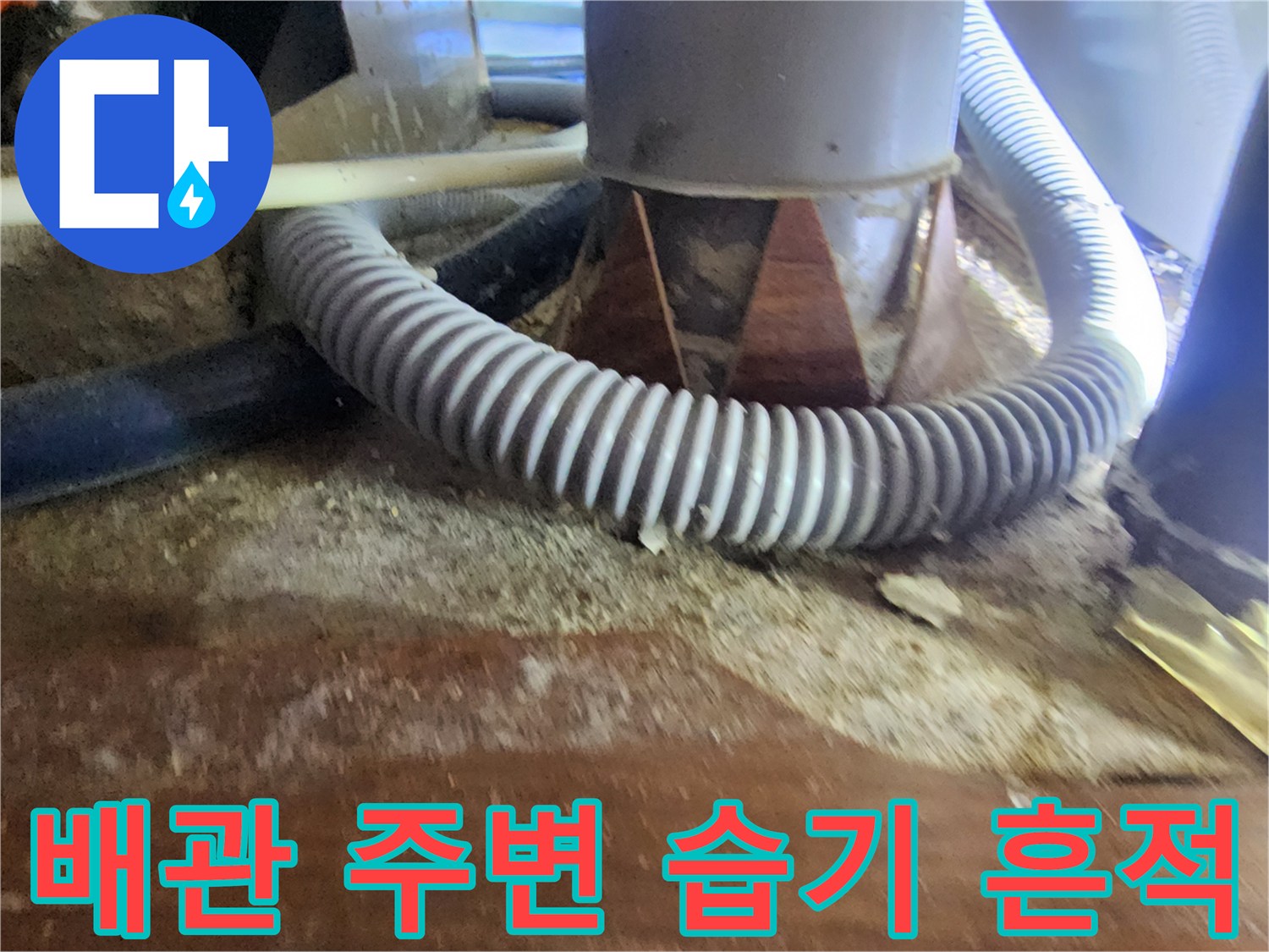 습기에 젖은 천장 목재와 회색 주름 배관의 근접 촬영