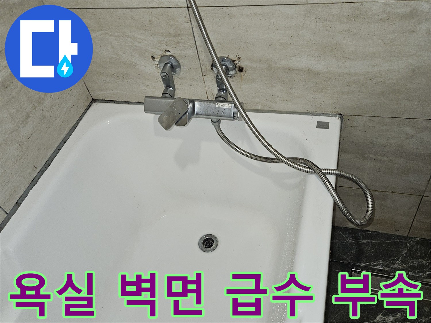 하얀색 욕조와 타일벽 사이의 변기용 직수 밸브