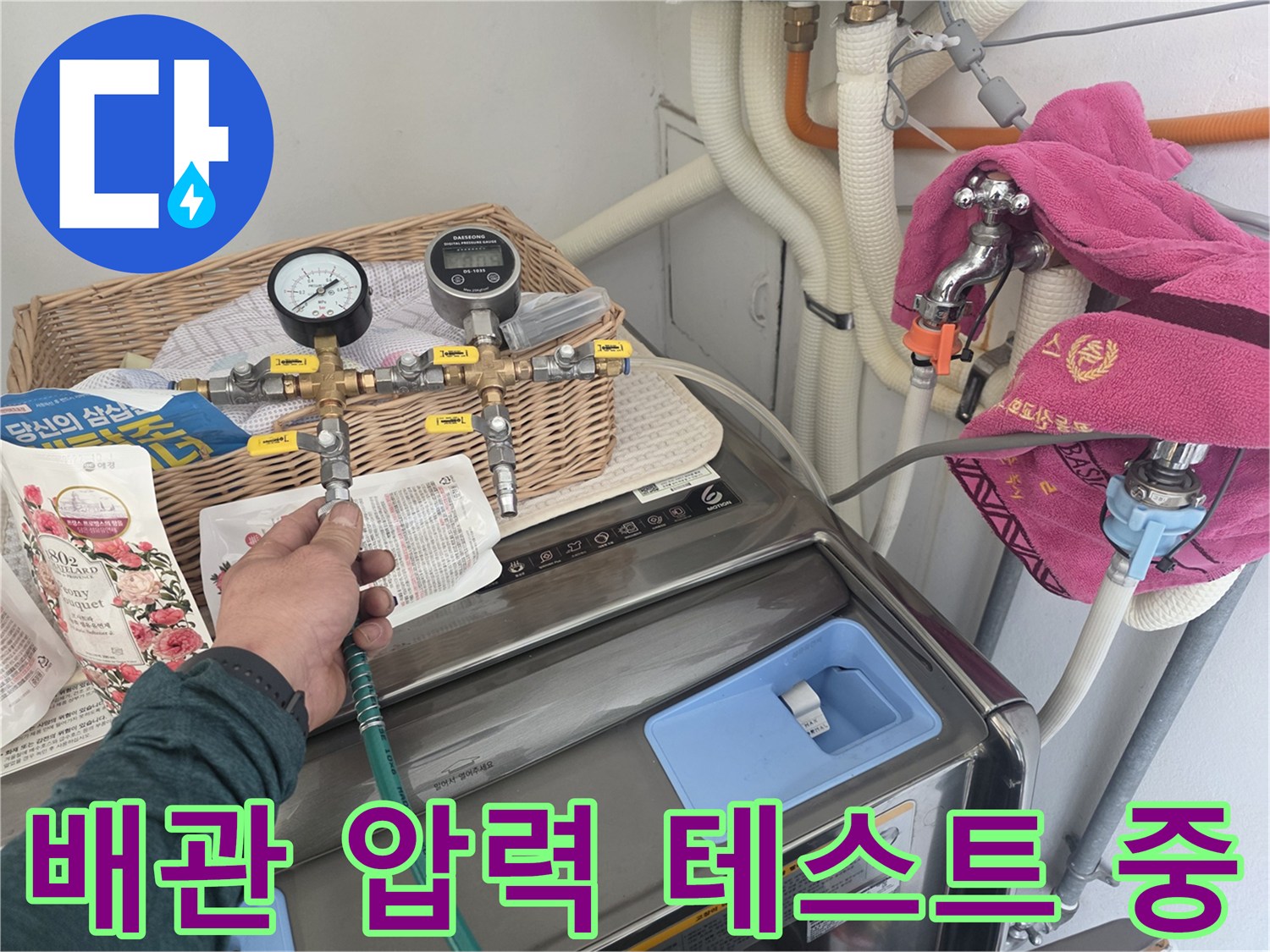 수도 배관의 기밀성을 확인하기 위해 압력계를 연결하여 공기압 테스트를 진행하는 모습입니다.