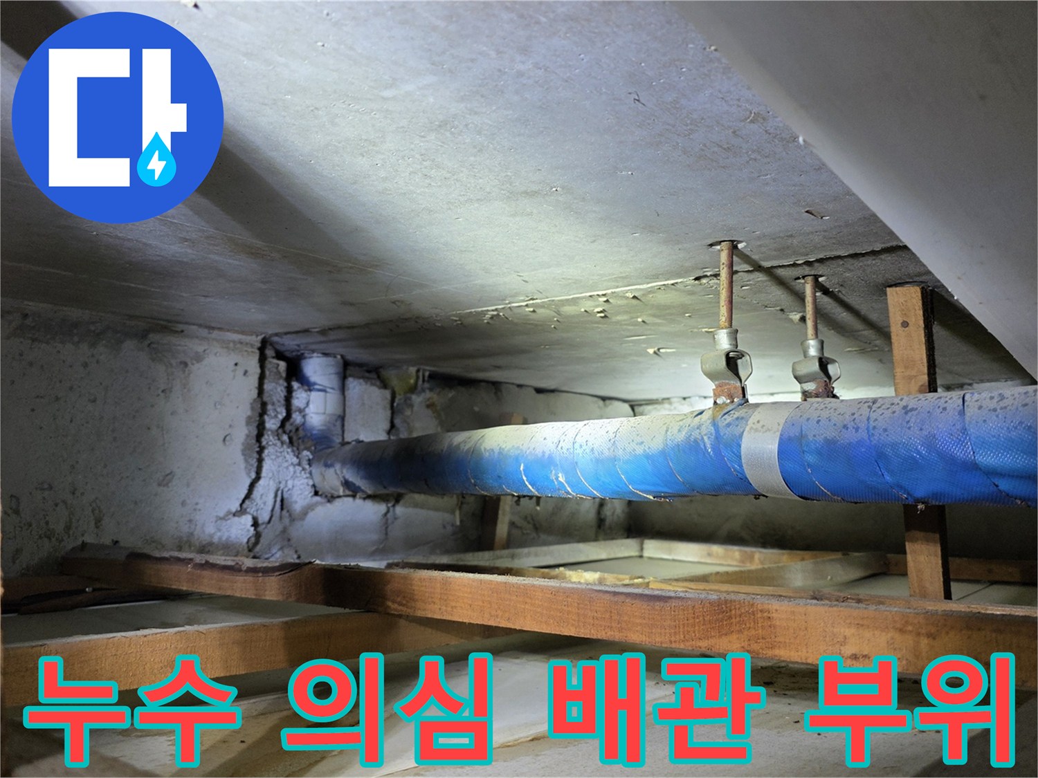 파란색 보온재로 감겨 있는 배관과 천장 목재 프레임의 모습
