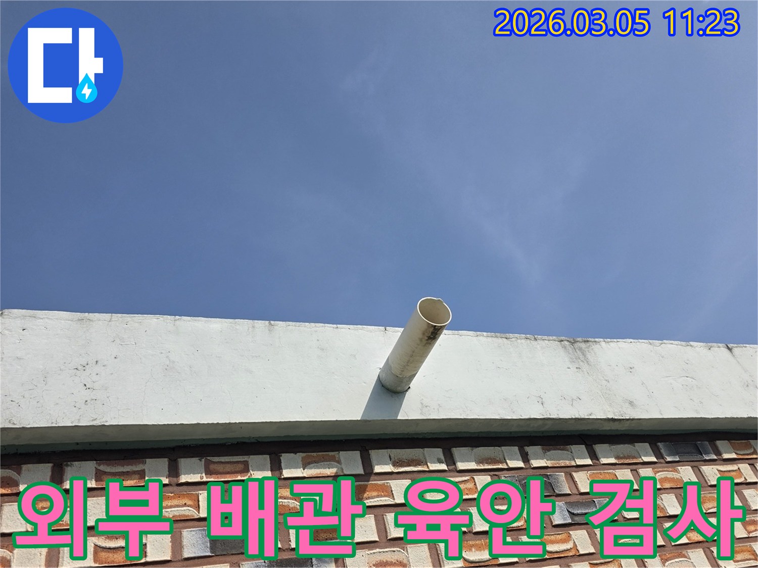 푸른-하늘을-배경으로-옥상-난간에서-돌출된-배수관의-육안-검사를-통해-누수-징후를-찾는-사진입니다.