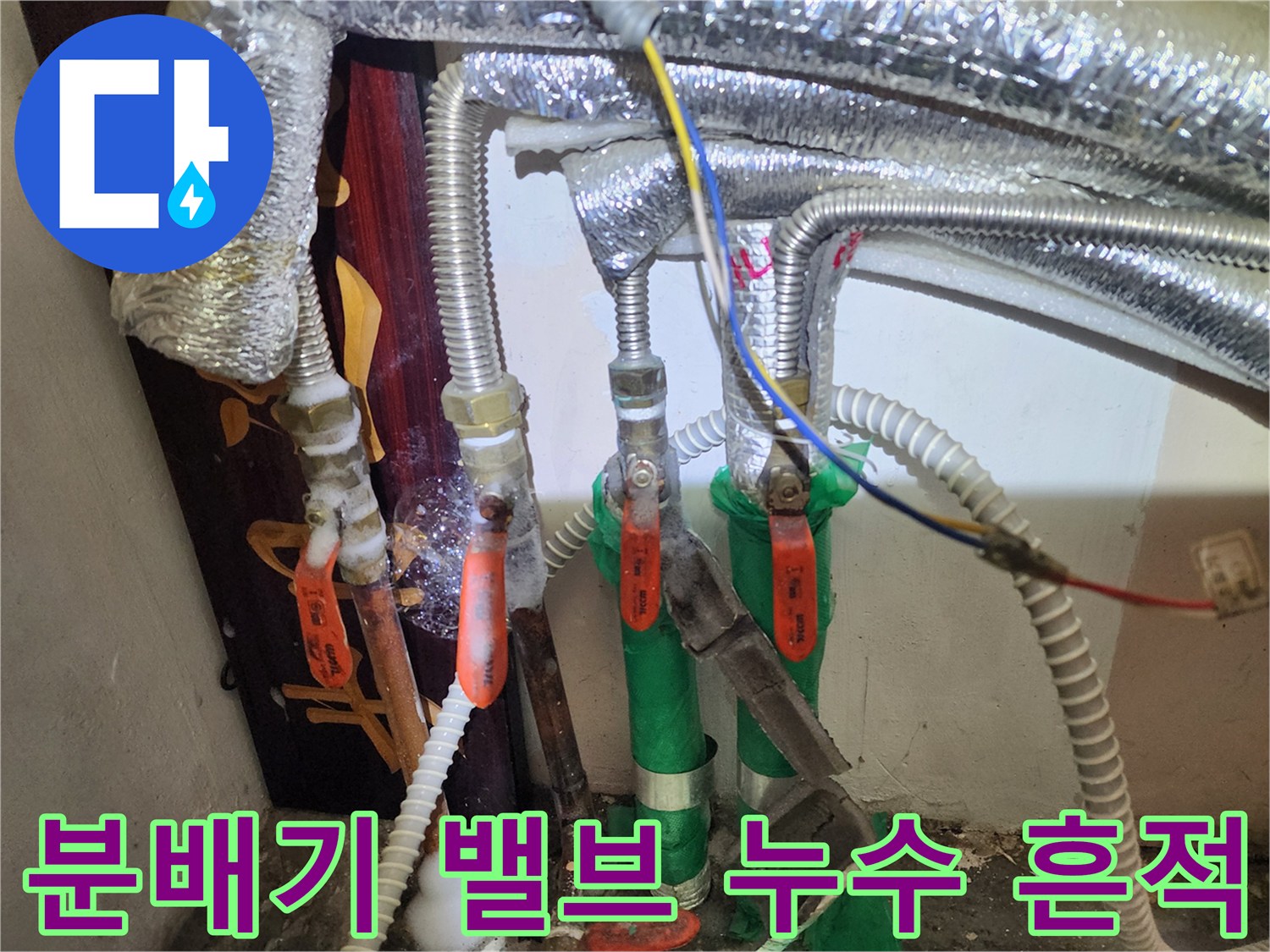 분배기 밸브와 은박 보온재가 씌워진 배관의 결합 상태를 보여줍니다.