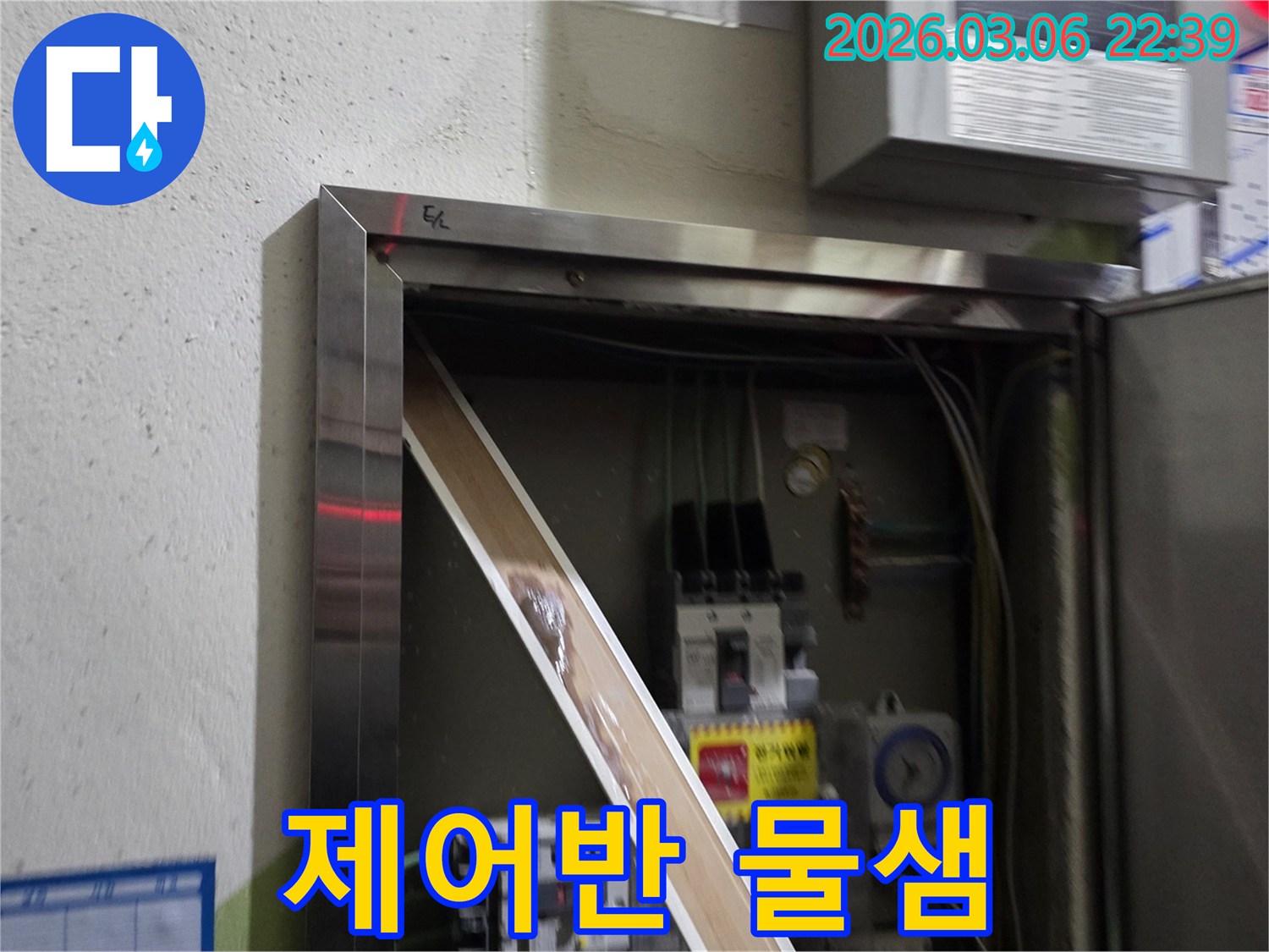 누수로 인해 전기 패널의 일부가-젖어있는 상태를-명확하게 보여주며-즉각적인 조치의 필요성을-알려줍니다.