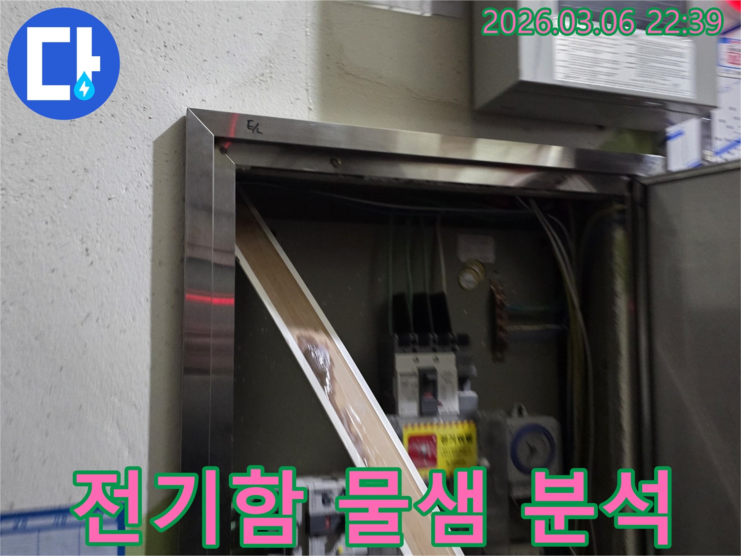 누수로 인해 전기 패널의 일부가-젖어있는 상태를-명확하게 보여주며-즉각적인 조치의 필요성을-알려줍니다.
