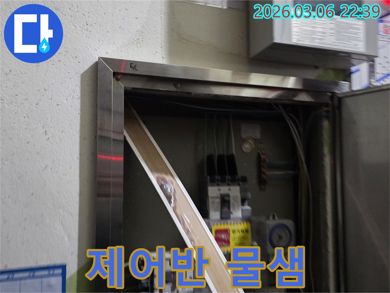 누수로 인해 전기 패널의 일부가-젖어있는 상태를-명확하게 보여주며-즉각적인 조치의 필요성을-알려줍니다.