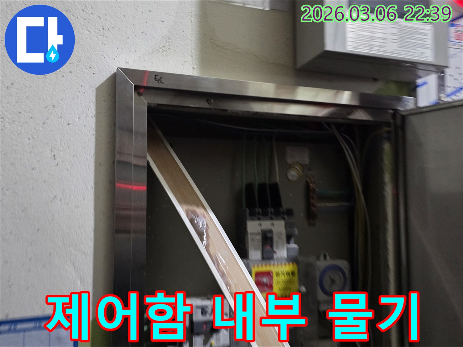 이 사진은 전기 제어함 내부로 물이 스며들어-전기 부품에 위험을 초래하는-심각한 누수 현장을-보여줍니다.