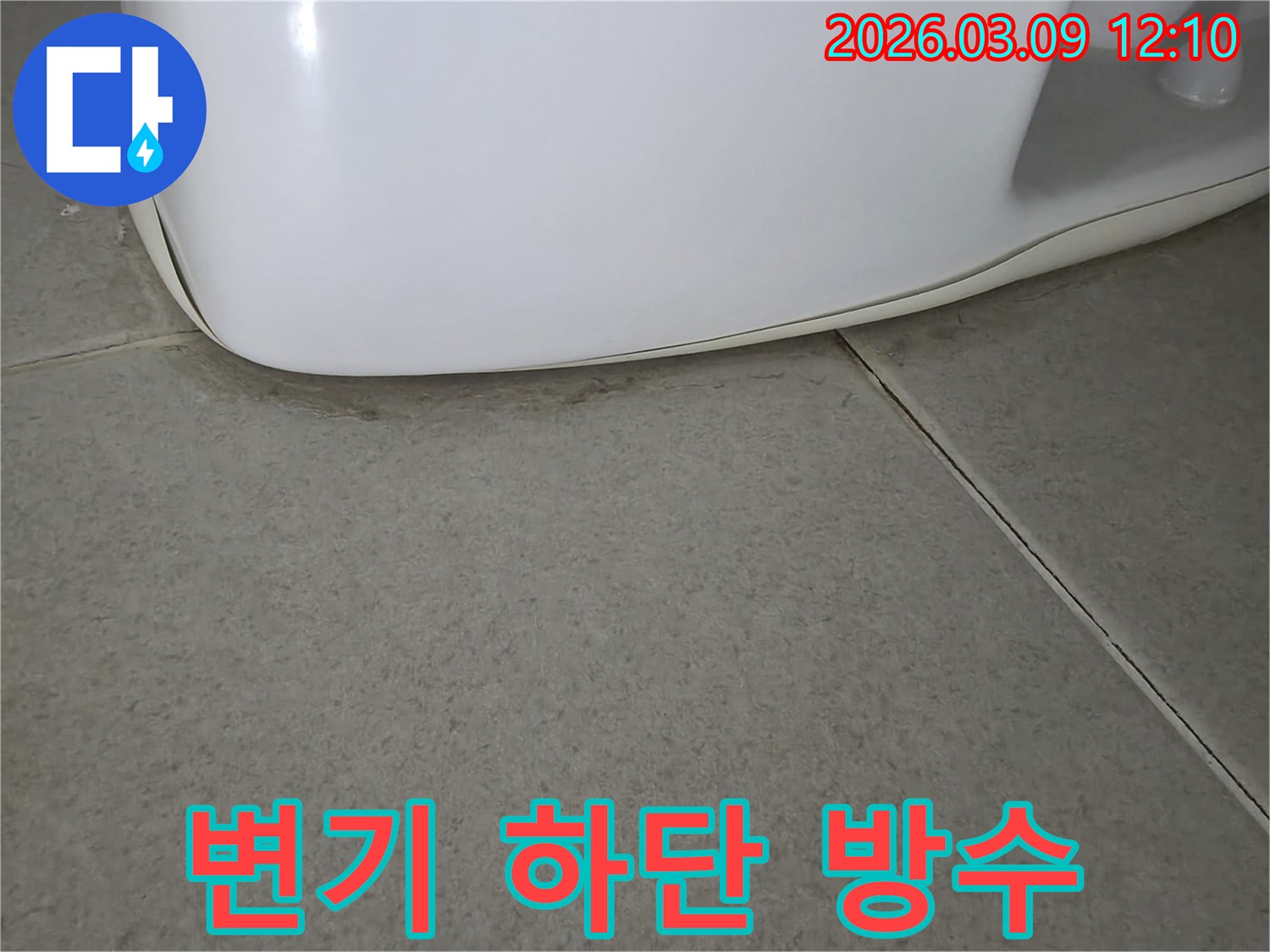 욕실 변기 아래-바닥 타일에-물기가 스며들어 생긴-어두운 얼룩으로-누수 발생을 시사하는-명확한 증거입니다