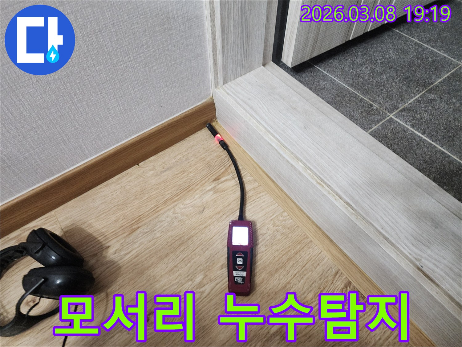 바닥과-벽-모서리에서-누수탐지기가-붉은빛으로-반응하며-숨겨진-물기를-찾아내는-모습
