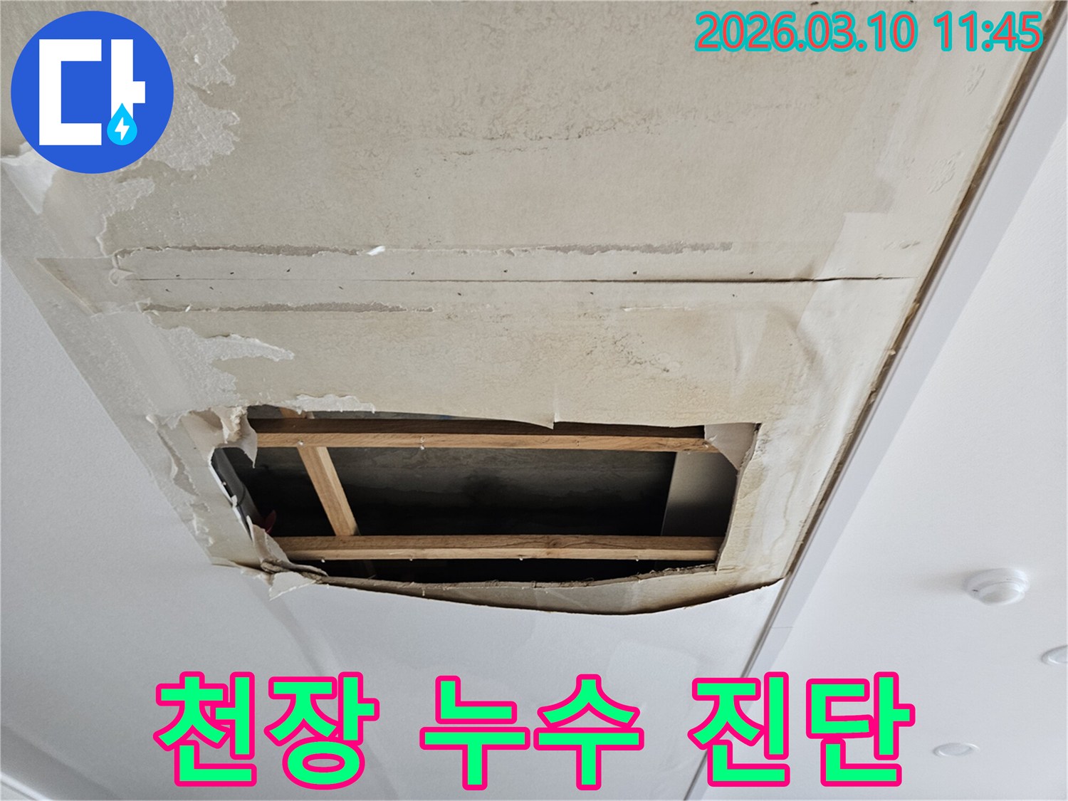 물이 스며들어-벽지가 부풀어 오르고-일부가 찢어져-천장 속 공간이-보이는 누수 현장입니다.
