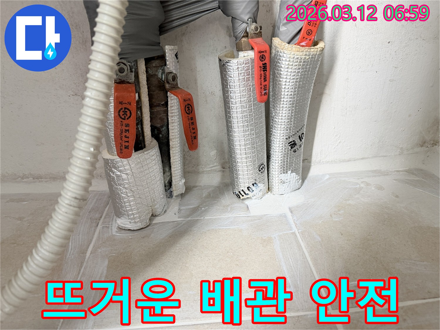 누수-공사-현장에서-뜨거운-배관의-안전을-위해-보온재를-시공하는-모습