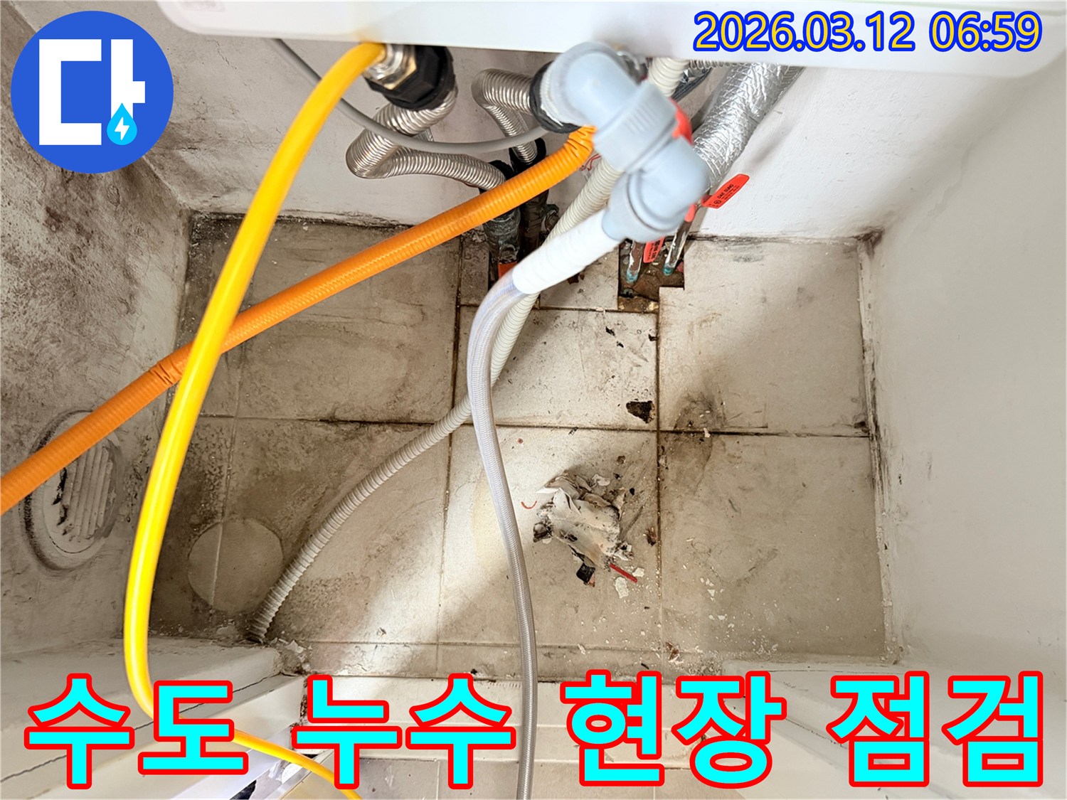 수도 배관들이 얽혀있고-바닥과 벽면에-오염과 물기가 보이는-누수 현장 모습입니다.
