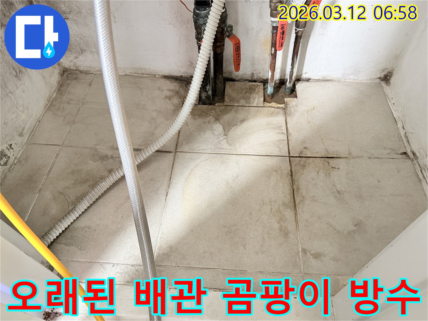 오래된-배관과-그-주변의-습기로-인한-타일-변색-및-벽면-손상을-보여주는-현장-사진