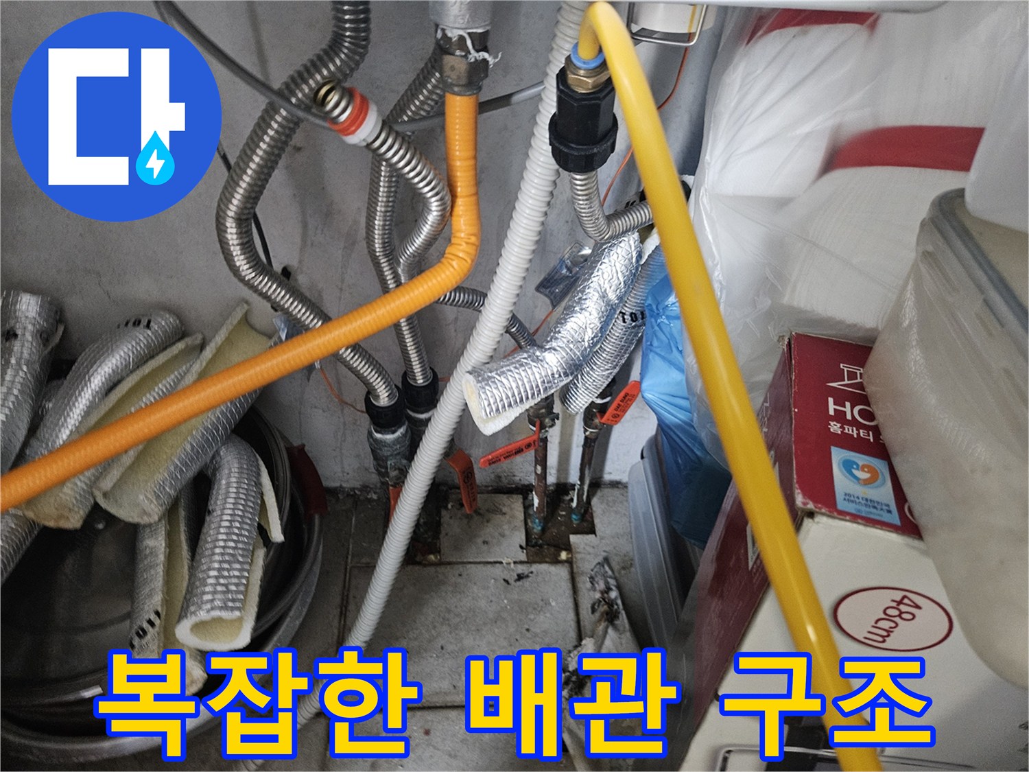 은색 주름관과 노란색 호스가 연결된 보일러실 내부 모습