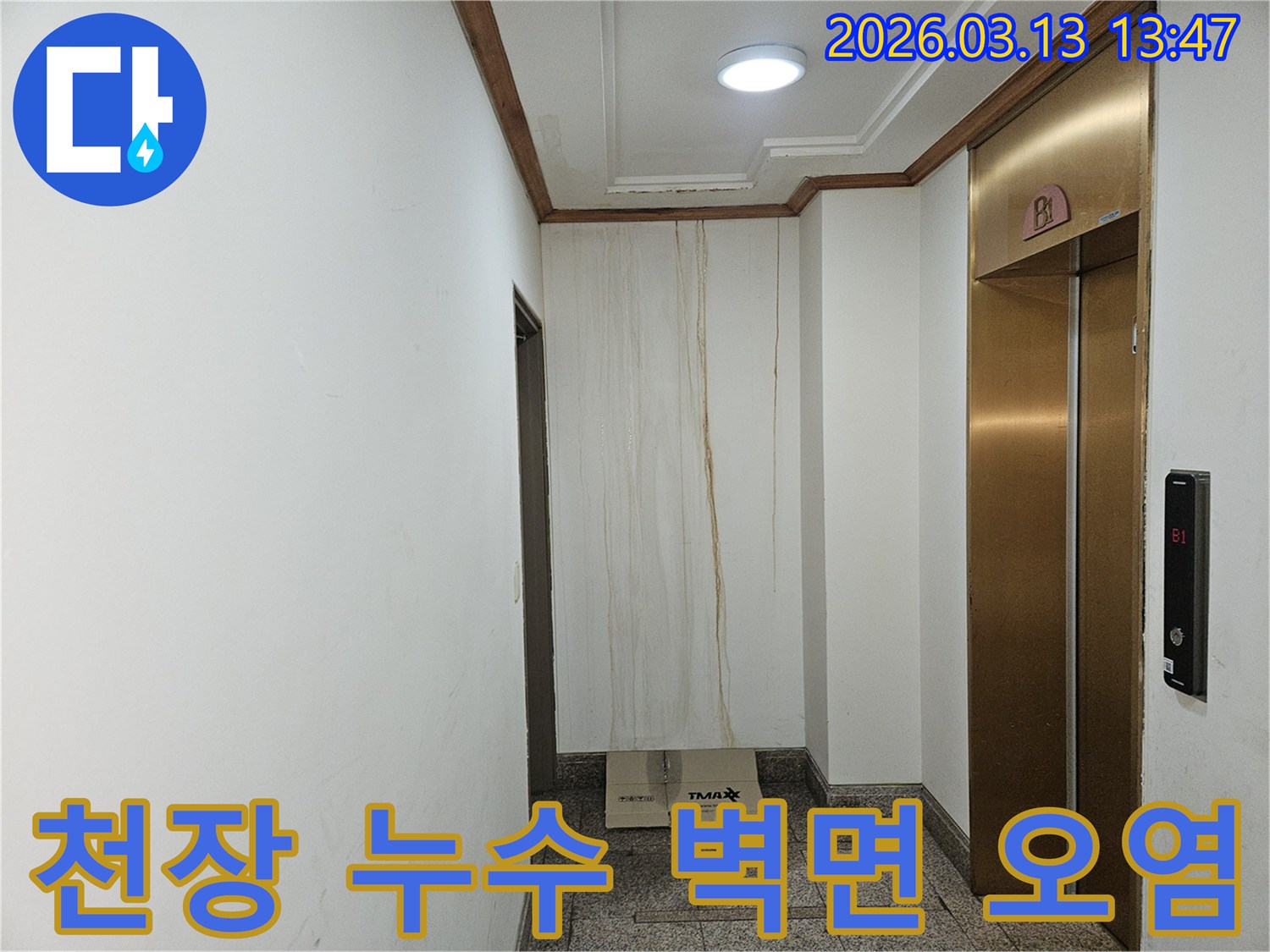 이 사진은 천장에서 시작된 누수로 인해-복도 벽면이 심하게 오염된 상황을 보여줍니다-물이 흘러내린 자국이 선명합니다
