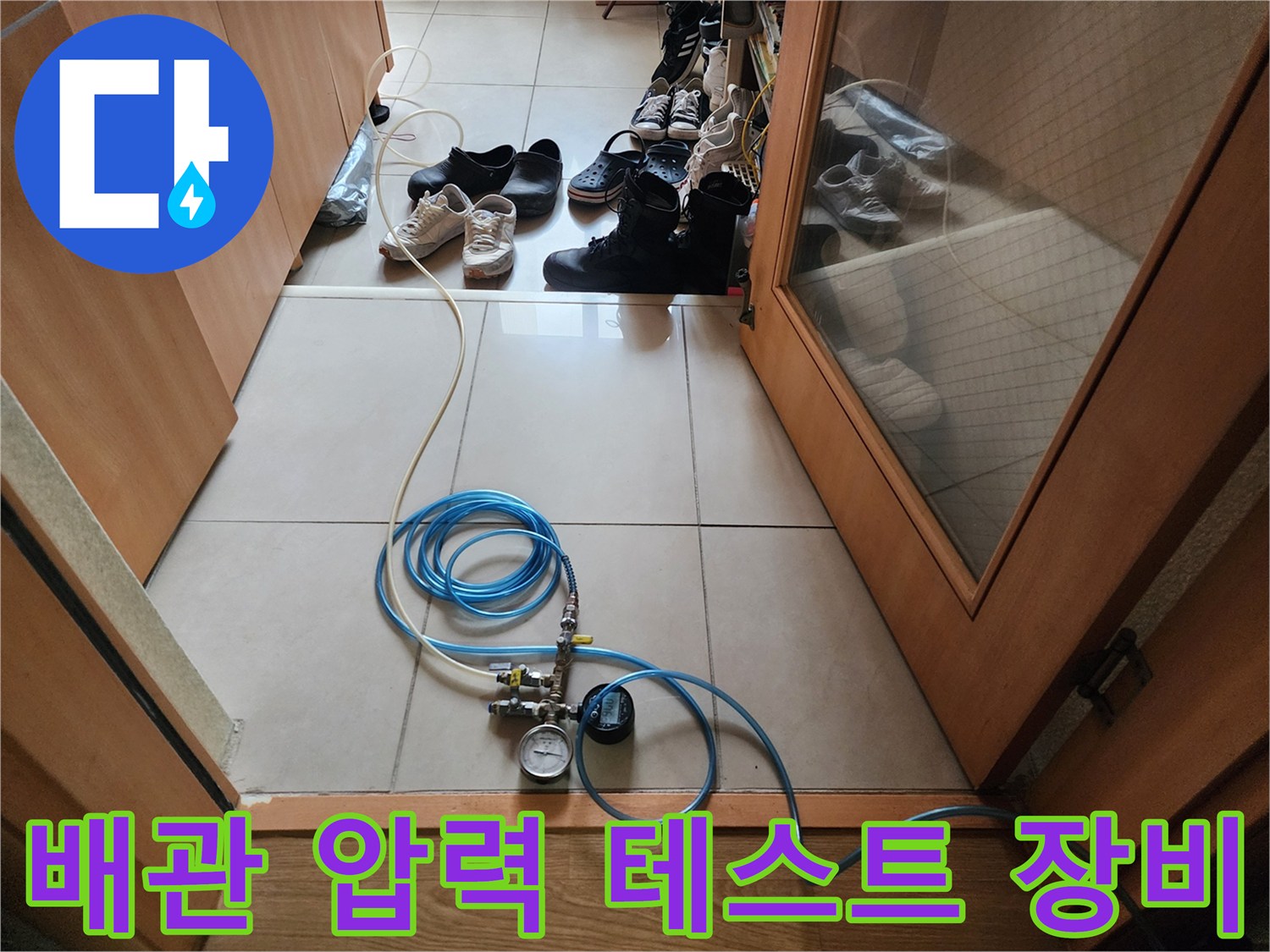 누수 진단을 위해 배관에 연결된 공압 테스트 장비와 파란색 호스 모습