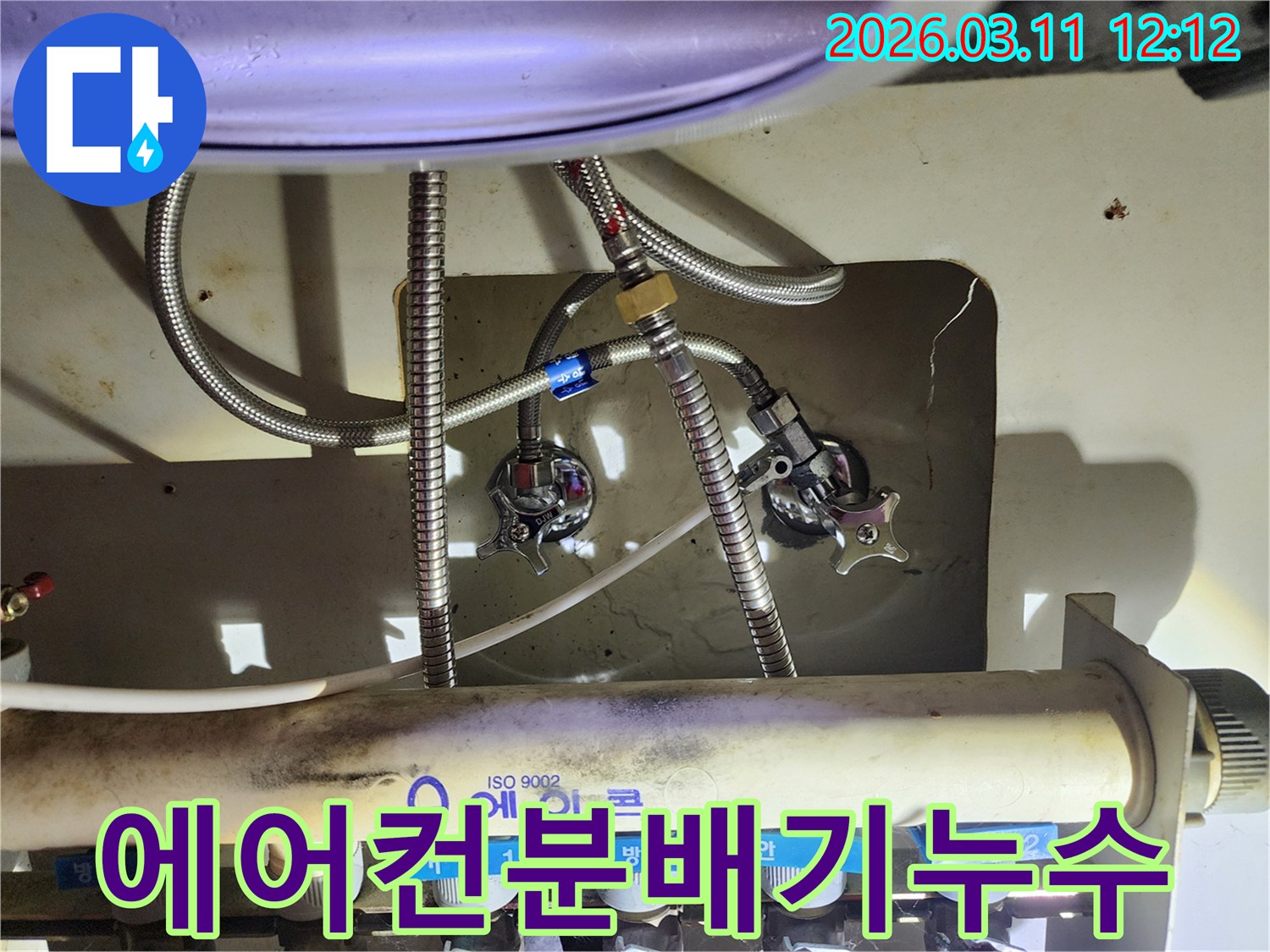 싱크대-아래-설치된-에어컨-배관-분배기와-연결된-수도-라인을-점검하는-사진