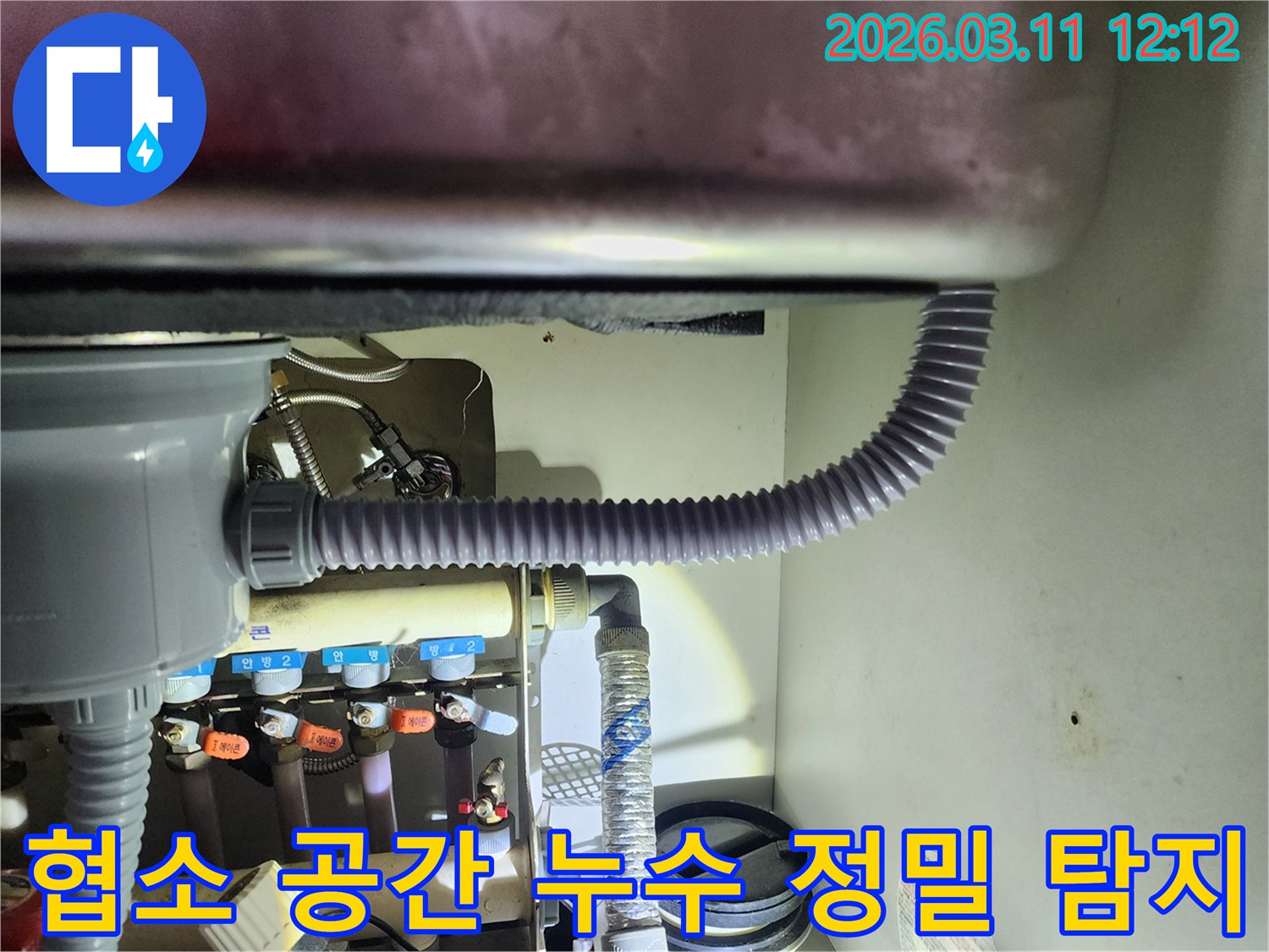 싱크대 하부의-좁고 어두운 공간에서-특수 장비를 활용하여-누수 지점을-정밀하게 탐지하는-작업 현장입니다