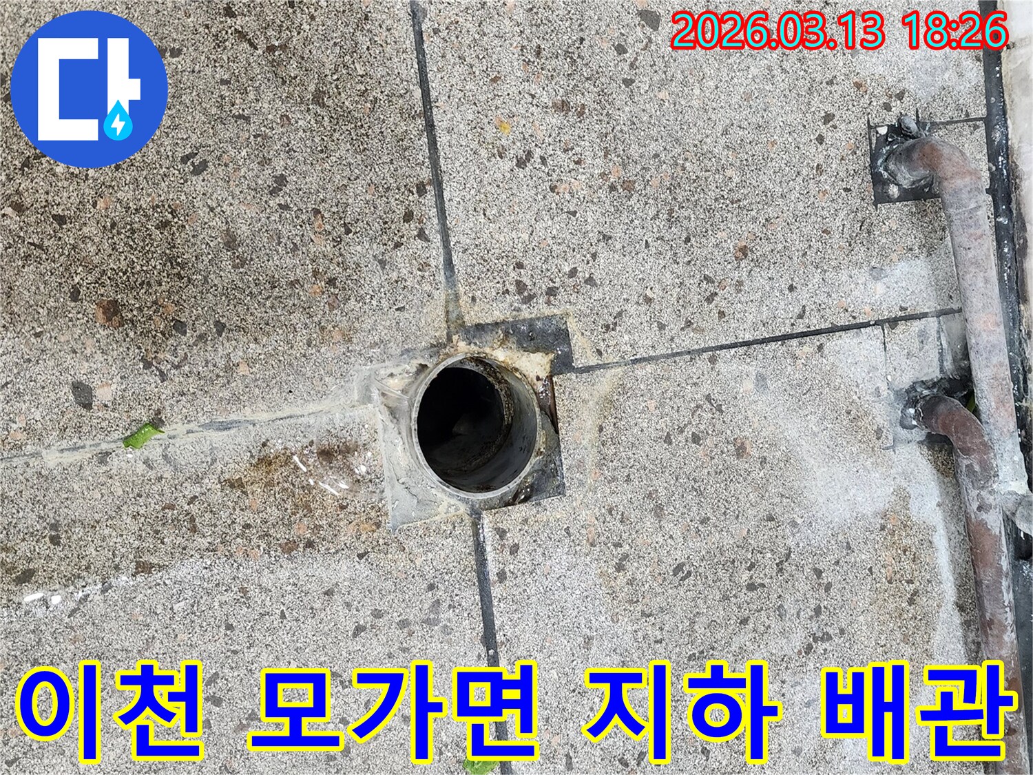 지하에-매설된-배관에서-발생한-누수로-인해-배수구-주변-콘크리트-바닥이-젖은-현장을-점검하는-모습