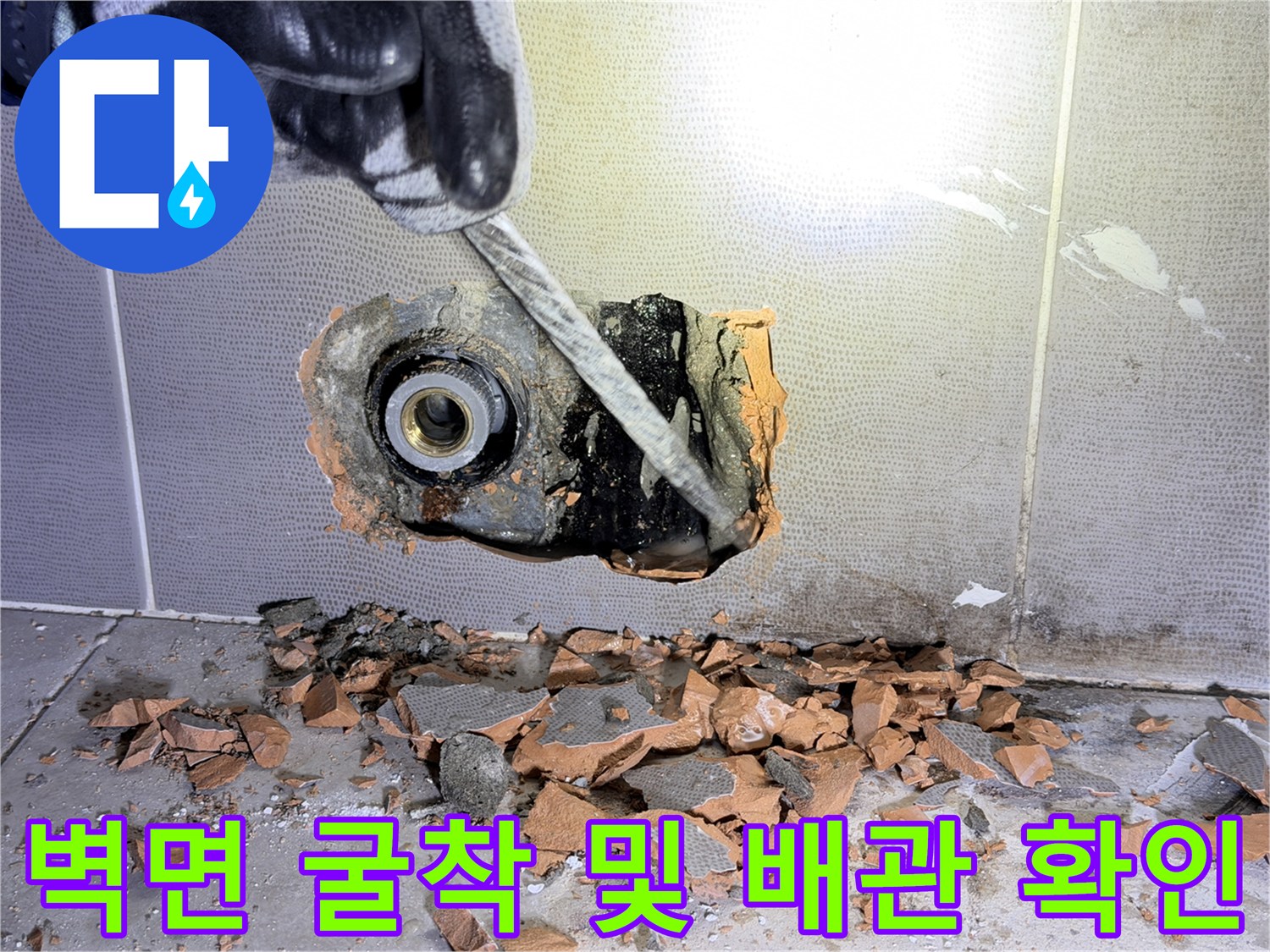 타일 제거 후 드러난 파손된 수도 부속과 주변 잔해물