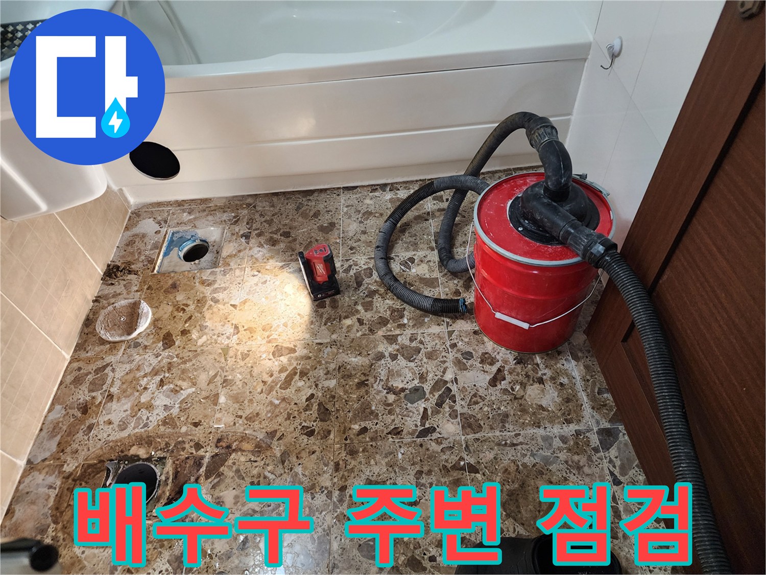 노출된 욕실 배수구와 작업용 흡입 장비의 모습