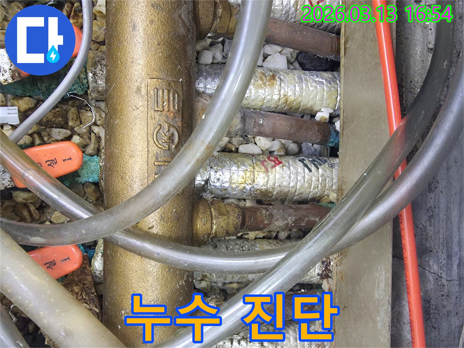 온수 분배기의-부식된 배관과-누수 흔적을-자세히-보여주는-클로즈업 사진입니다.