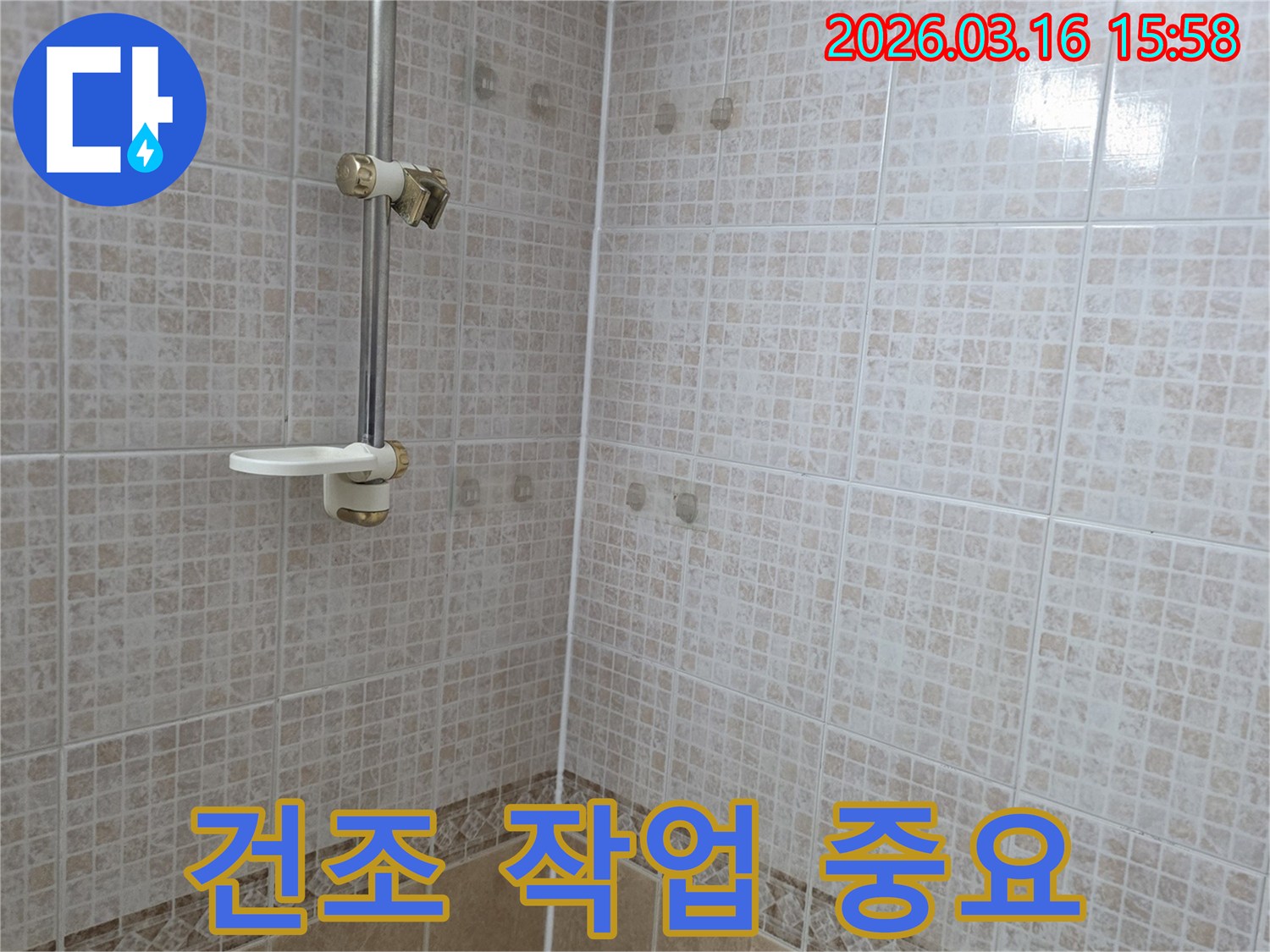 욕실 천장 타일에 물이 새어 생긴-얼룩을 해결한 후 내부 습기를-제거하기 위한 건조 작업의-중요성을 누수 전문가가 설명하는 모습