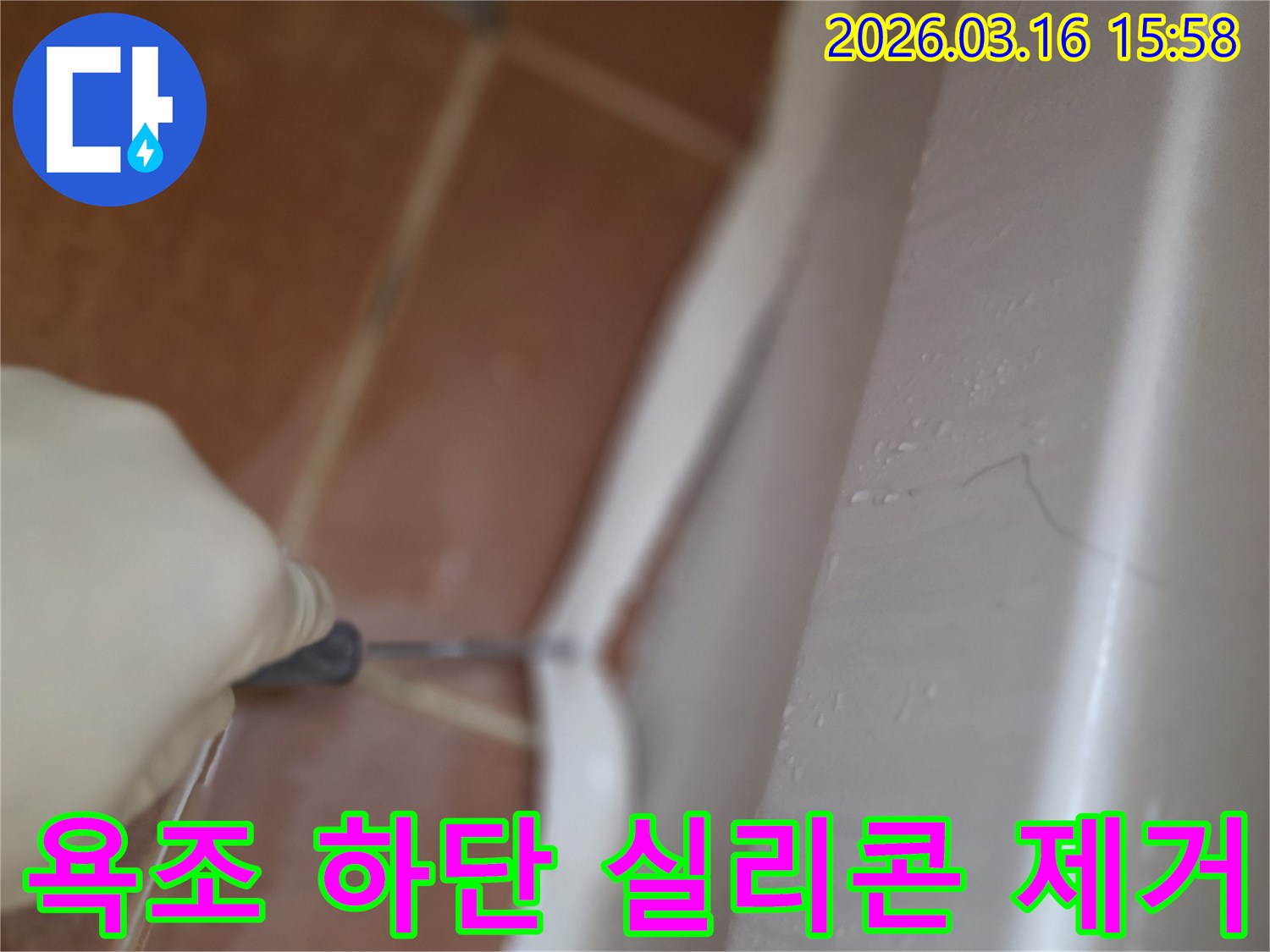 욕조 하단의-오래되고 곰팡이 핀 실리콘을-전문가가 제거하는 작업 현장