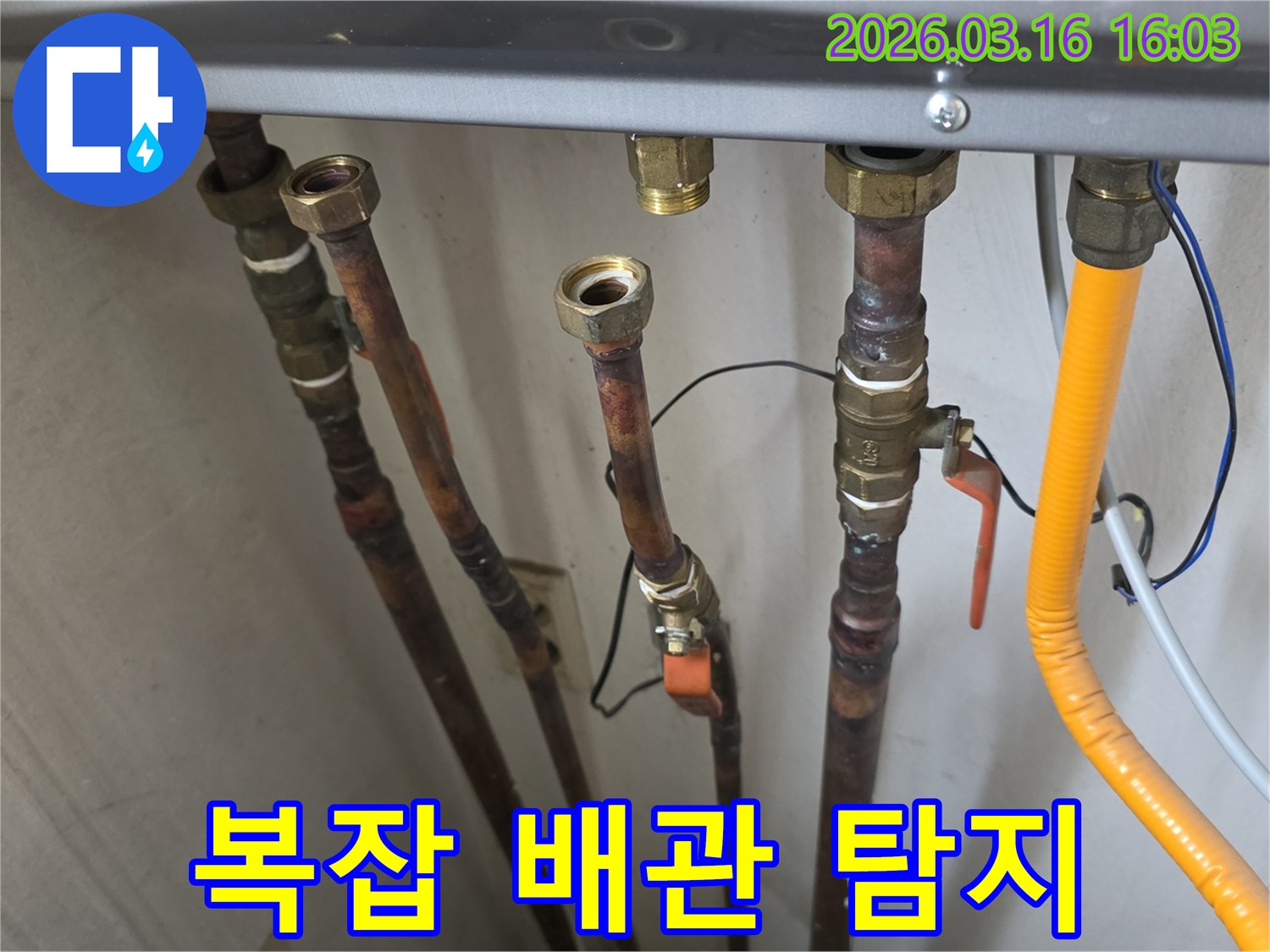 보일러 하부의 복잡하게 연결된 배관들 사이에서-누수 지점을 찾아내기 위해-정밀하게 탐지하는 모습
