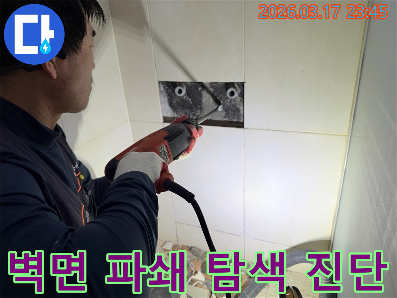 누수 전문가가 사무실 벽면 타일을 깨끗하게 파쇄하며-누수 원인인 배관의 문제점을 정밀하게 탐색하고 진단하는 작업을 진행 중입니다.