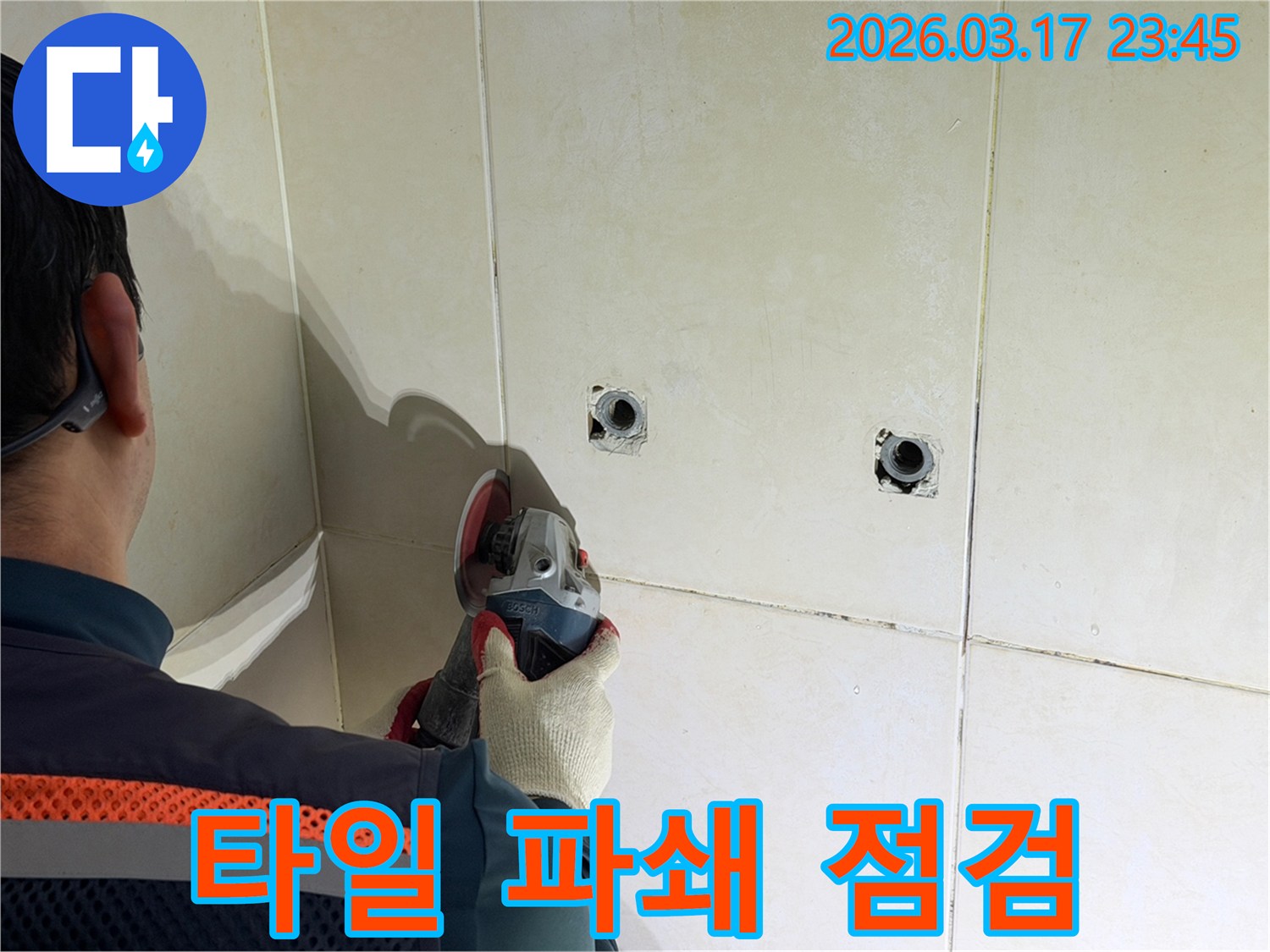 누수 지점 확인 후-전문가가-타일 벽면을-파쇄하고-배관을-점검하는-작업을-진행하고-있습니다