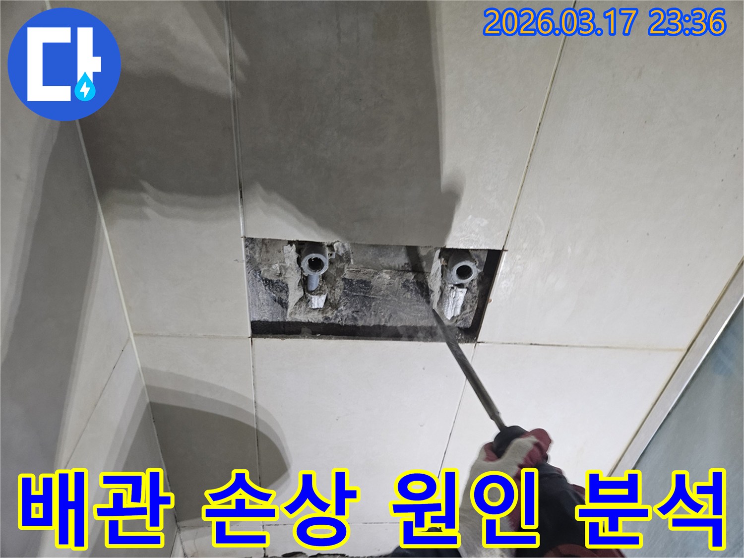 누수탐지-전문가가-욕실 벽면 타일을-조심스럽게 파쇄하여-배관 손상 원인을-분석하는 모습