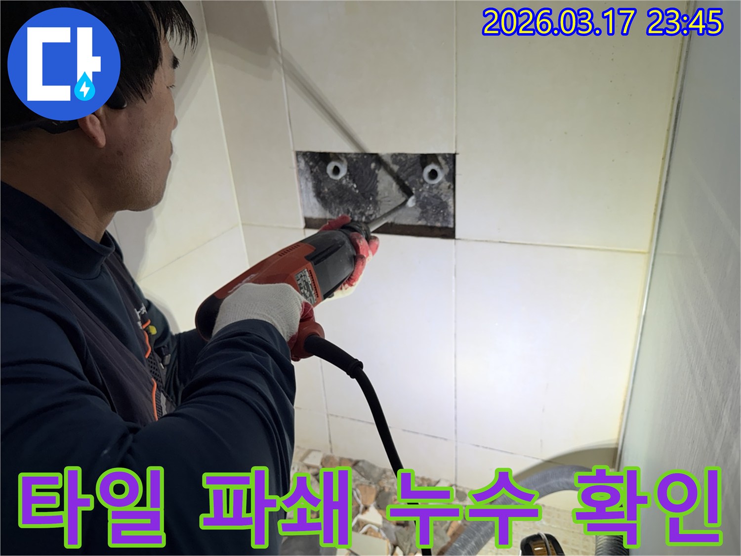 숙련된 기술자가 누수 지점을 찾아내기 위해-벽면 타일을 깨고 내부 배관을 드러내는 작업을 진행하고 있습니다.