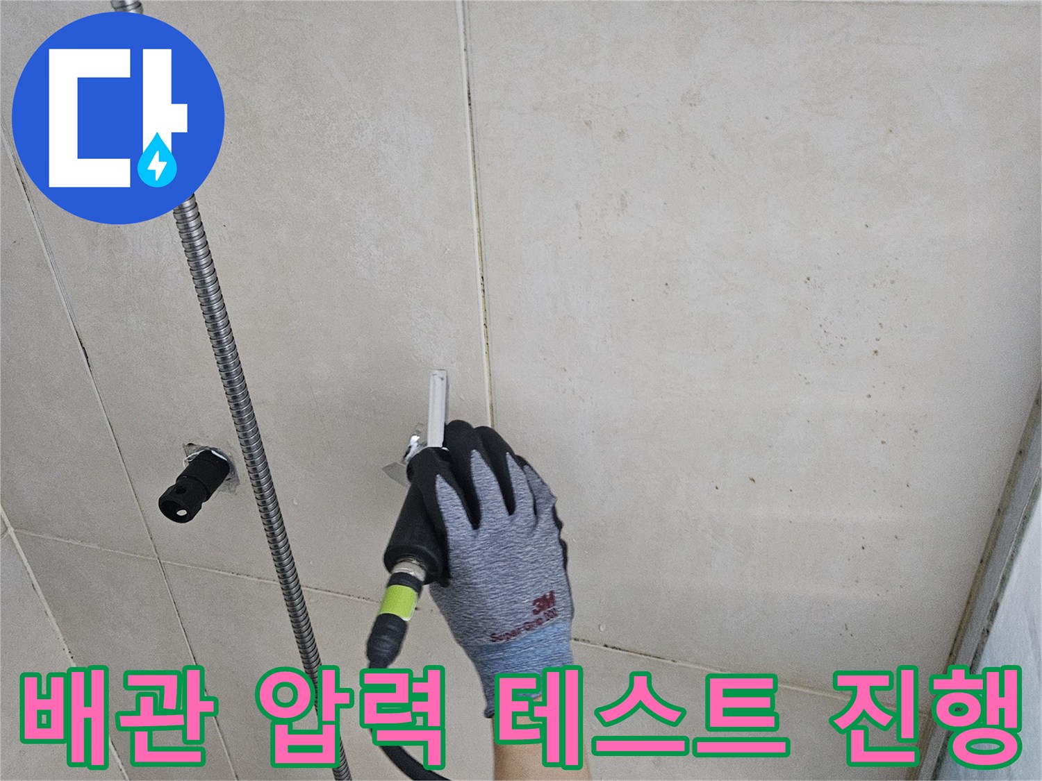 작업용 장갑을 착용한 손이-수전 부위 배관 검사기를 조절하는 장면