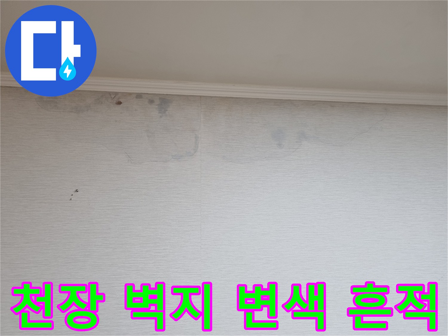 아파트 천장 벽지 상단에 발생한 어두운 얼룩과 변색된 부분
