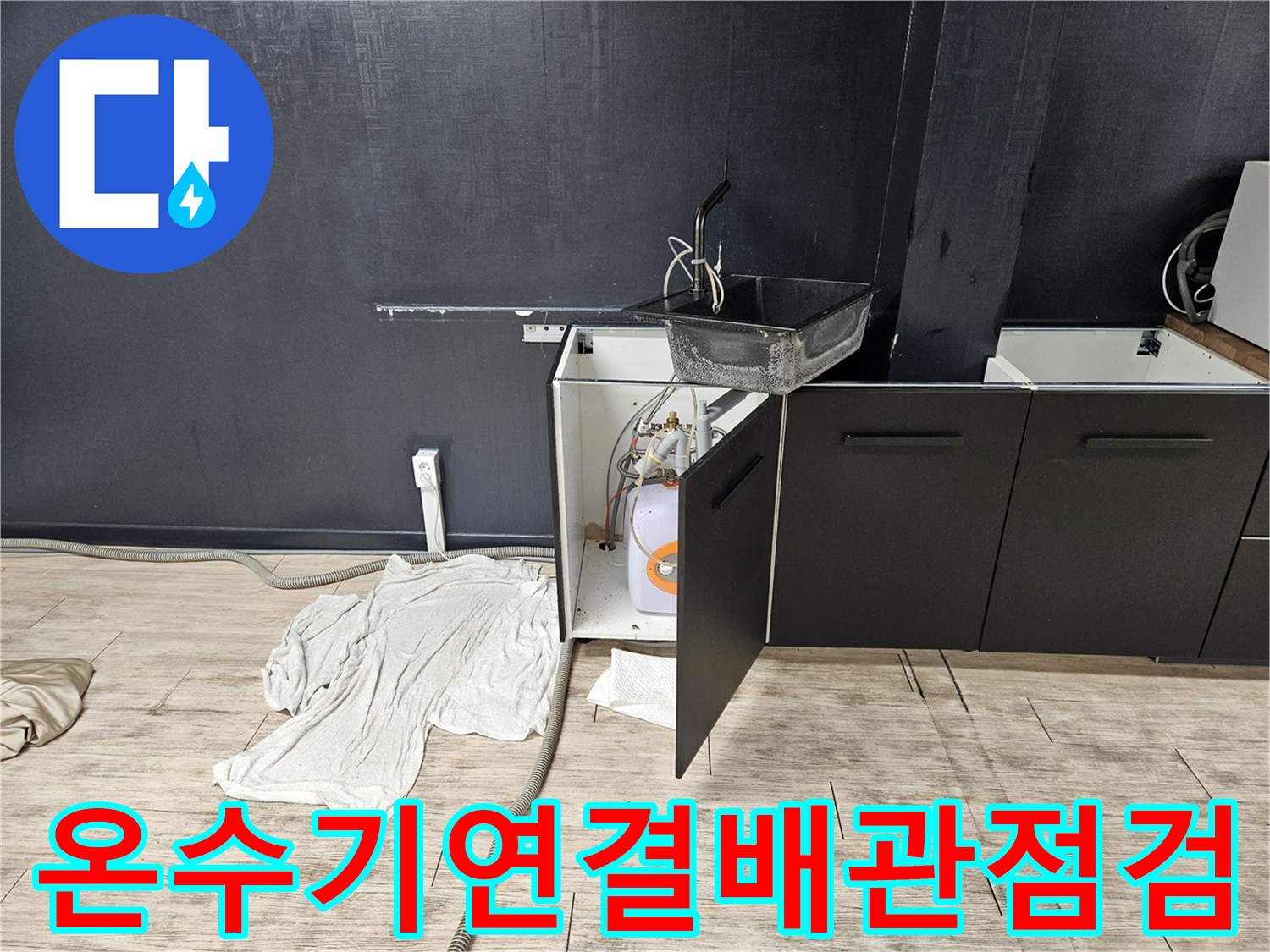 싱크대-하단-공간에-설치된-온수기와-주변의-배관-라인