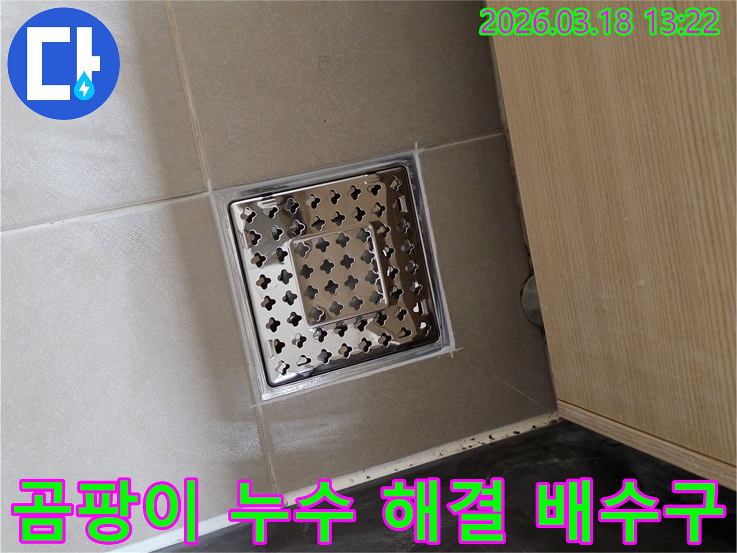 새롭게 설치된 스테인리스 스틸 바닥 배수구가-주변의 깔끔한 타일 마감과 함께-곰팡이와 누수 문제를 동시에 해결한 모습을 보여줍니다.