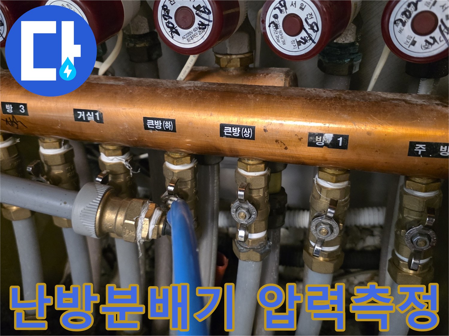 난방분배기에 연결된 파란색 호스와 공압 테스트 장비 모습