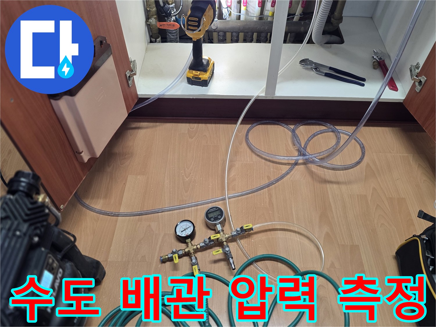 싱크대 밑 분배기에 연결된 압력 게이지와 테스트 호스